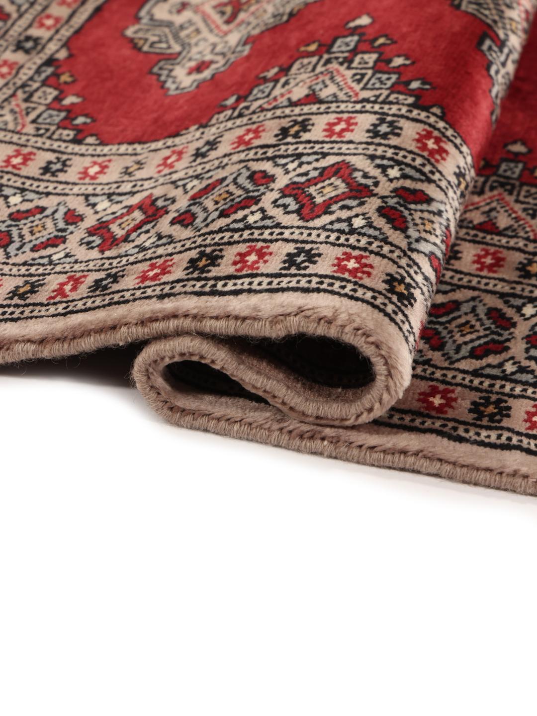 Hand-knotted Pakistan Bokhara rug with a red field and geometric motifs