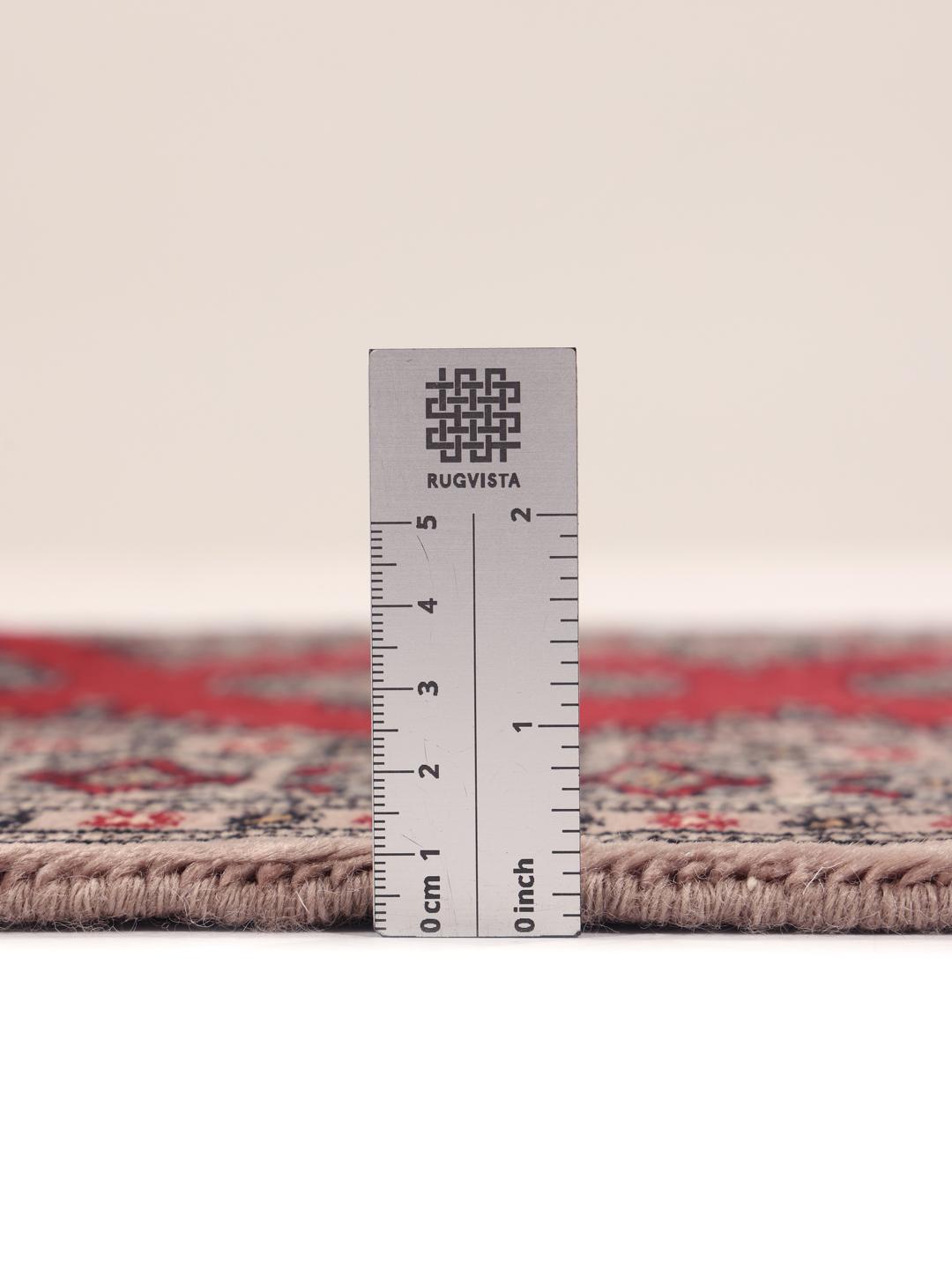 Hand-knotted Pakistan Bokhara rug with a red field and geometric motifs