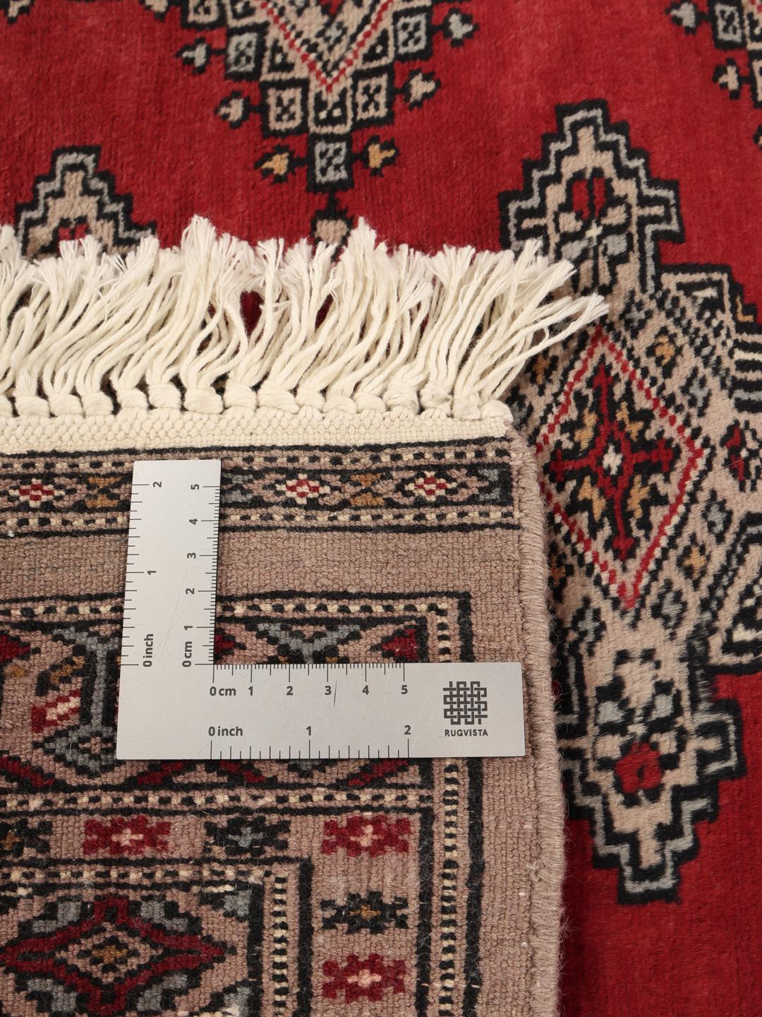 Hand-knotted Pakistan Bokhara rug with a red field and geometric motifs