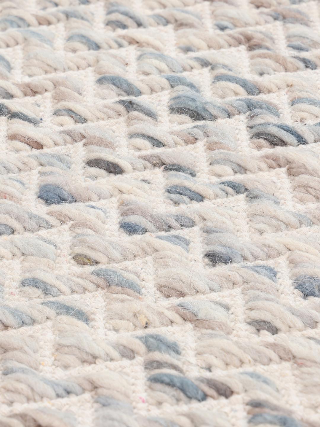Un long tapis de couloir présentant un motif chevron délicat dans des tons de crème et de gris clair