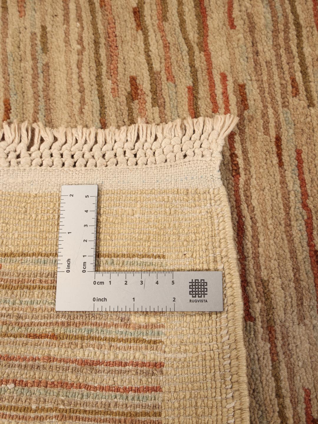 Håndknyttet afghansk tæppe i beige med horisontale teksturmønstre.
