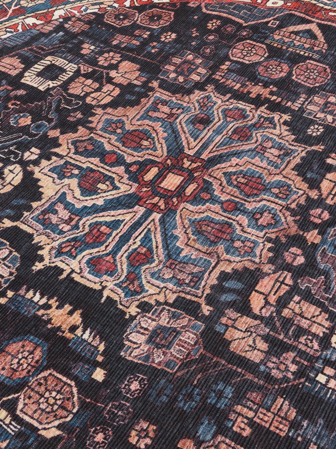Round rug in blue and black with intricate Oriental patterns