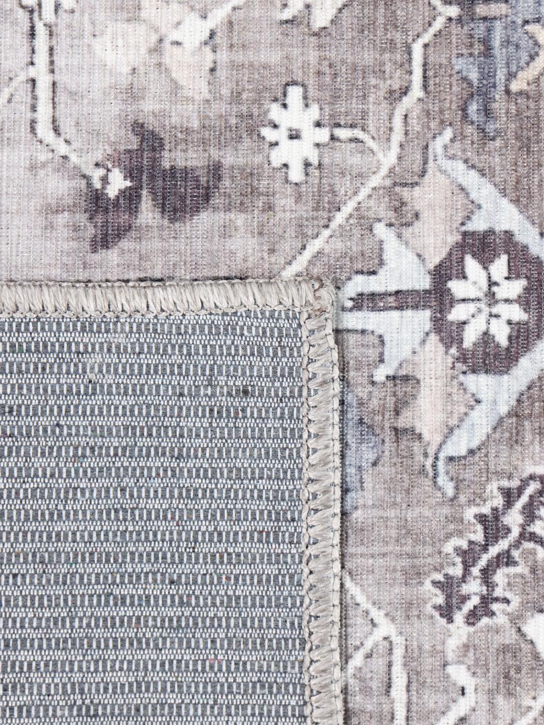 Rechthoekig grijs en beige vloerkleed met een traditioneel oosters patroon.