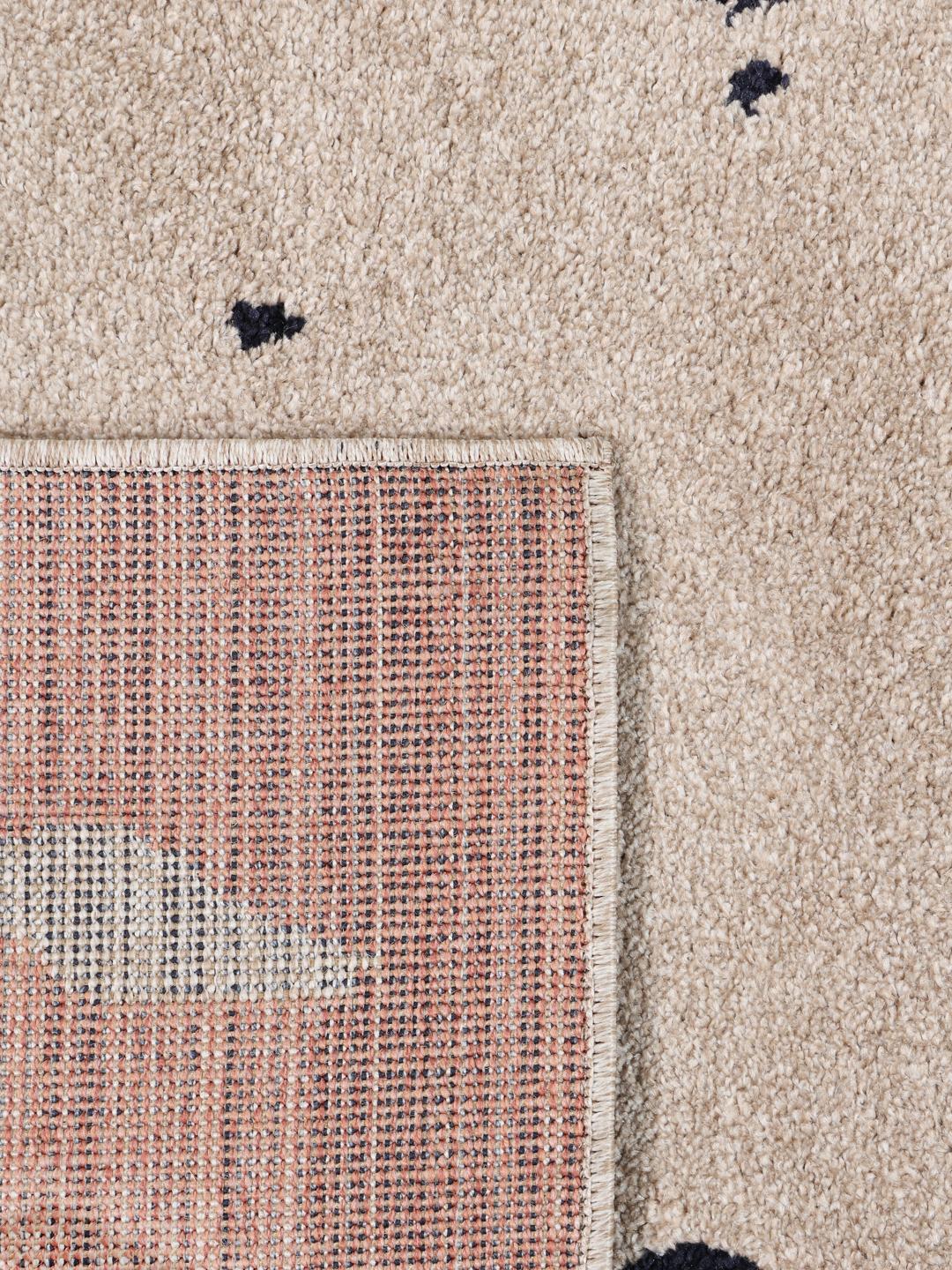Rektangulært blåt og beige tæppe med et abstrakt mønster.