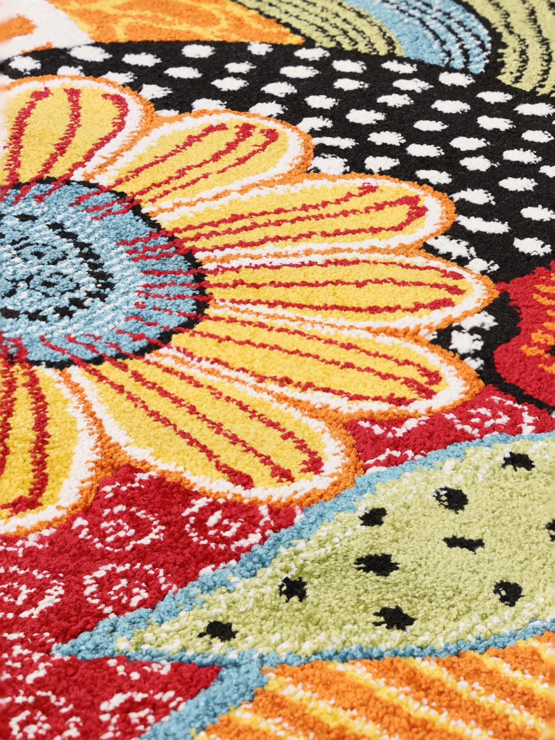 Et flerfarvet tæppe med et kunstnerisk blomster- og karakterdesign
