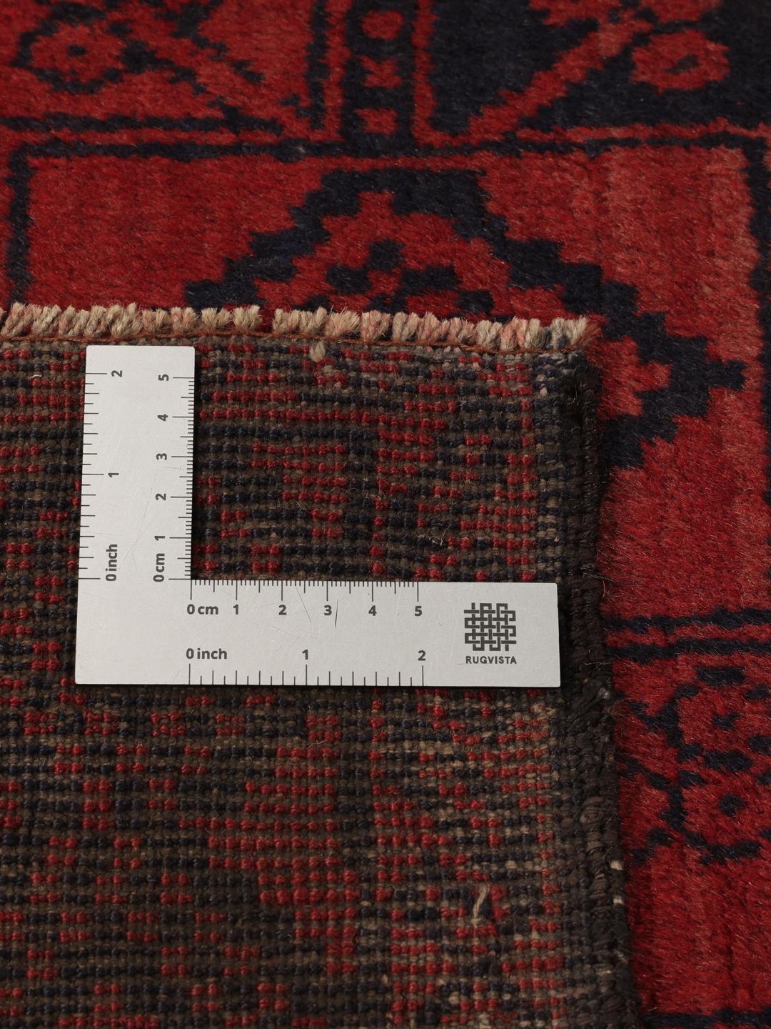 Ręcznie wiązany dywan Beluch z Afganistanu z ciemnoczerwonym i czarnym wzorem geometrycznym.