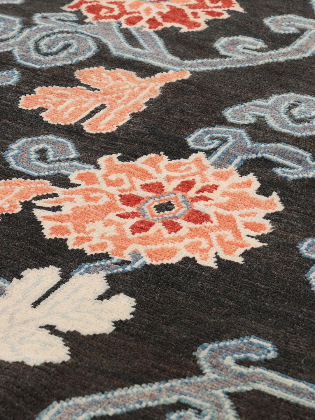 Alfombra Kazak afgana anudada a mano con campo negro y patrones florales