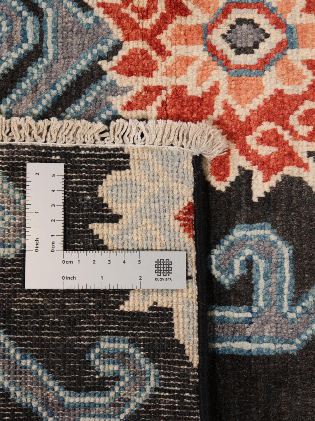Alfombra Kazak afgana anudada a mano con campo negro y patrones florales