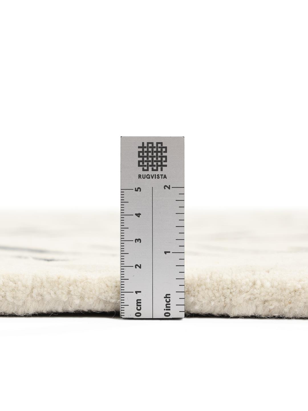 A rectangular rug with a white background and a black hand-tufted chevron pattern.