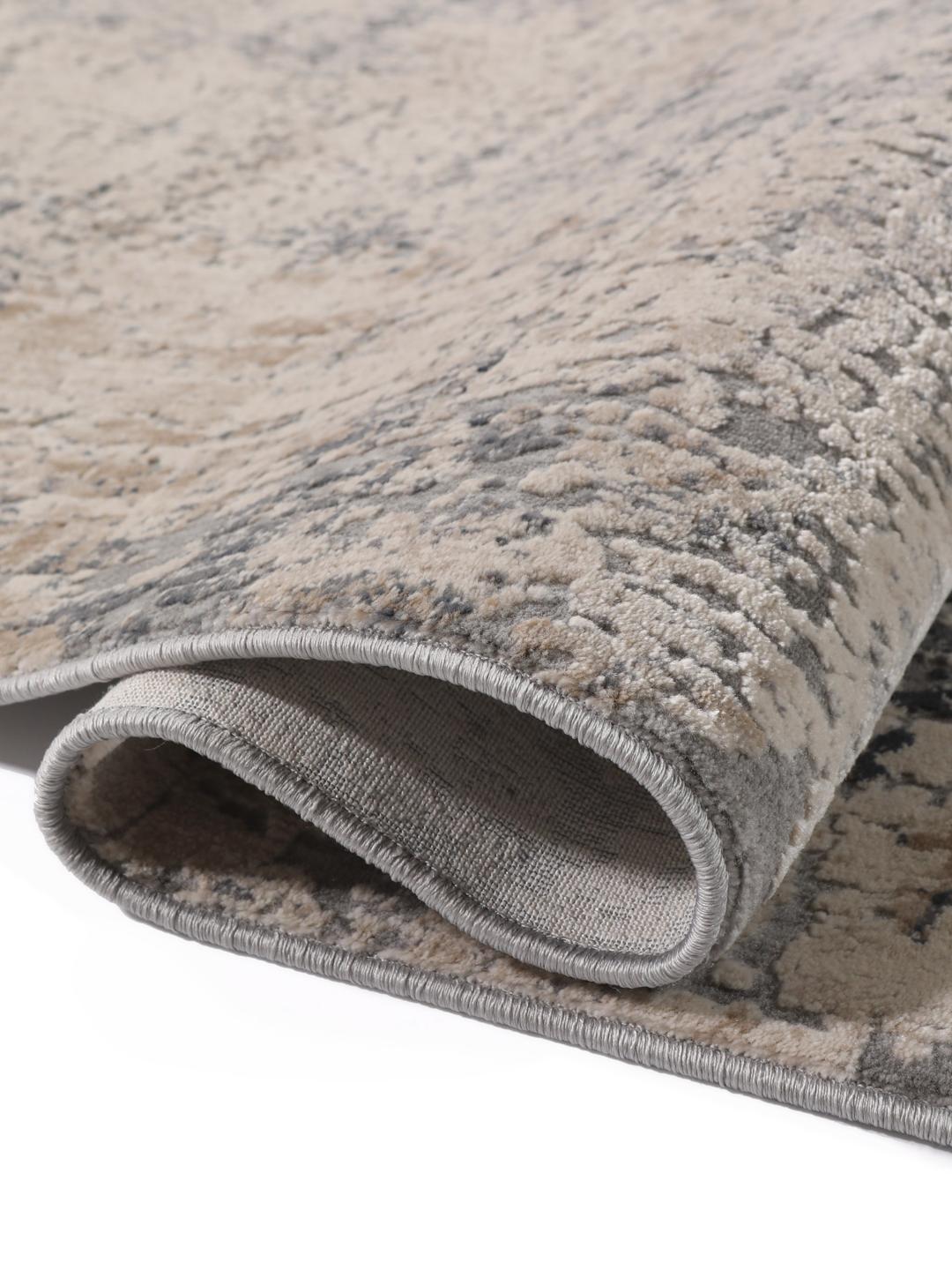 Een lange loper met een getextureerd, abstract patroon in grijze en beige tinten.