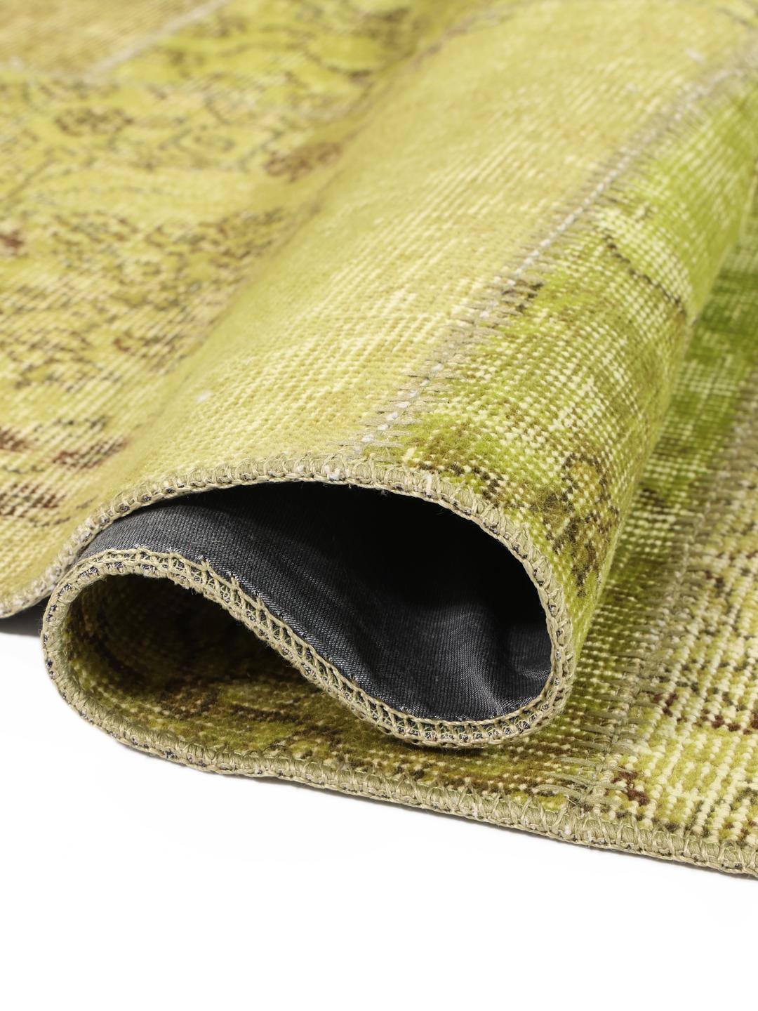 Et rektangulært håndlavet patchwork-tæppe fra Tyrkiet med en levende grøn farvepalette.