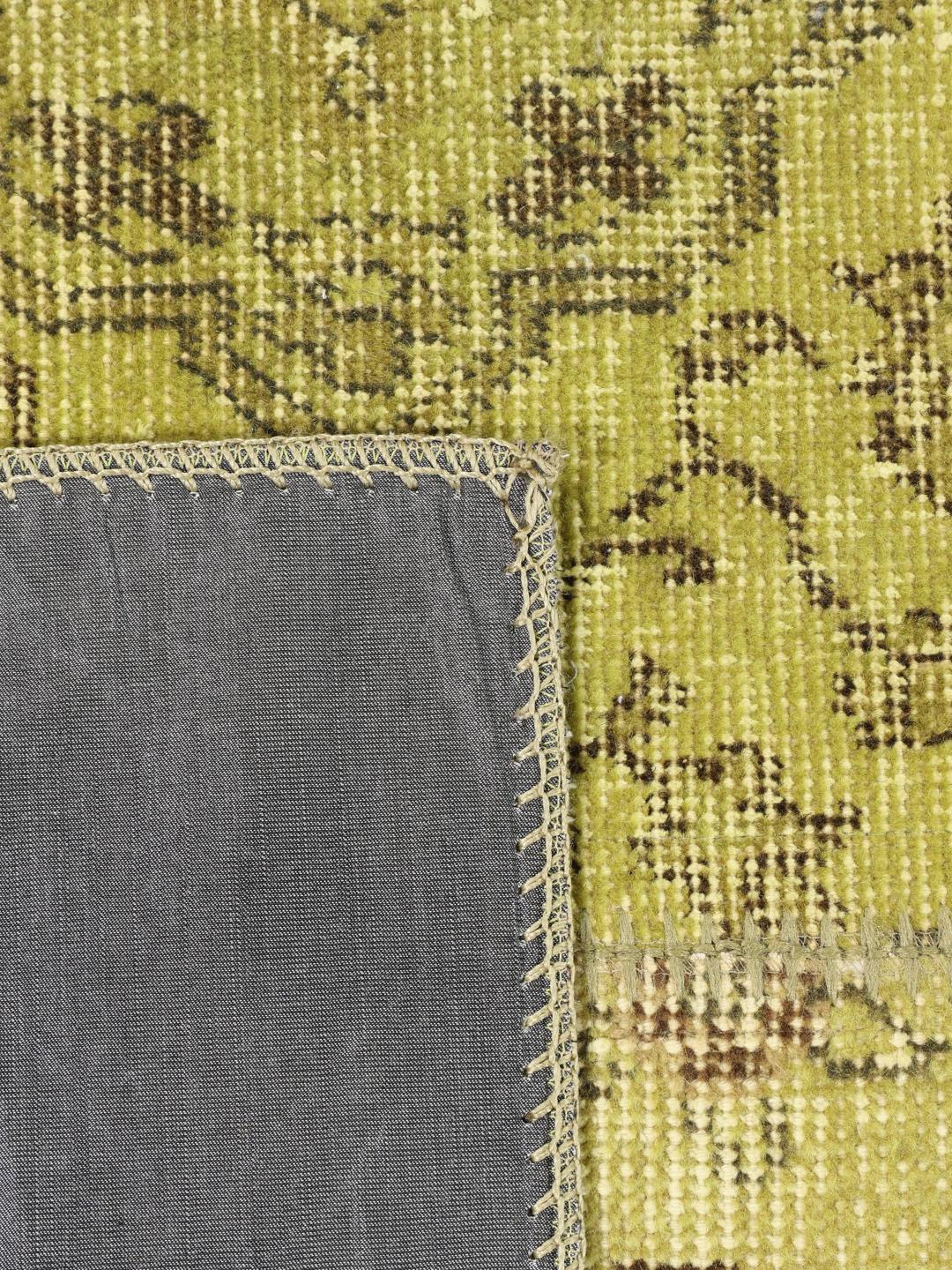 Et rektangulært håndlavet patchwork-tæppe fra Tyrkiet med en levende grøn farvepalette.