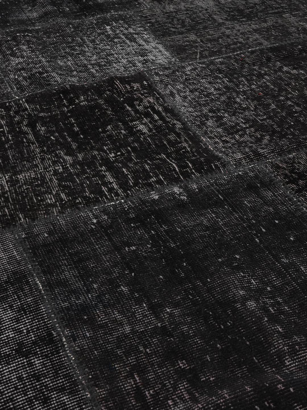 Duży prostokątny dywan patchworkowy z Turcji o monochromatycznym czarnym wzorze.