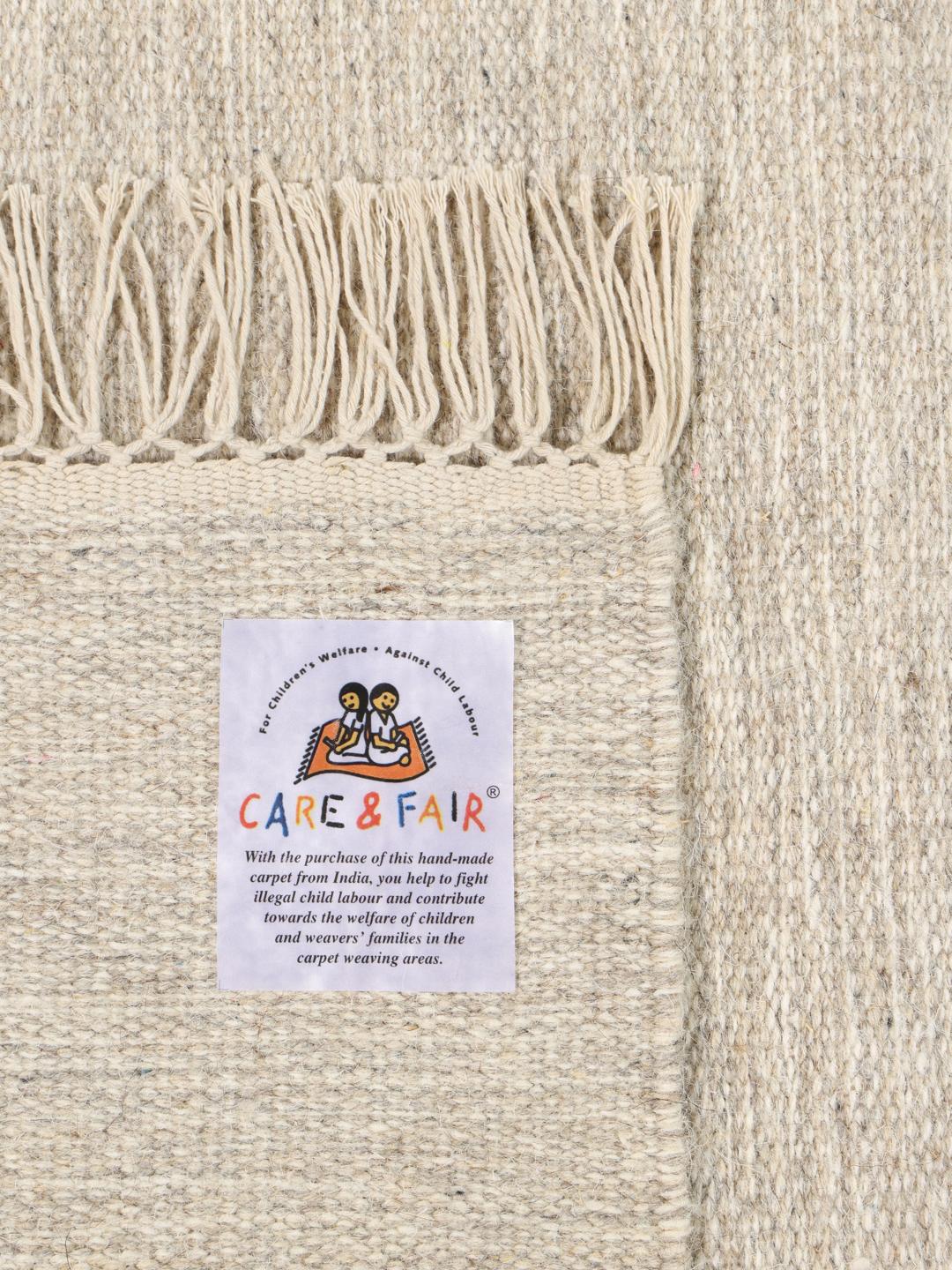 Beige tapijt met een eenvoudige geweven textuur en franjes aan de uiteinden