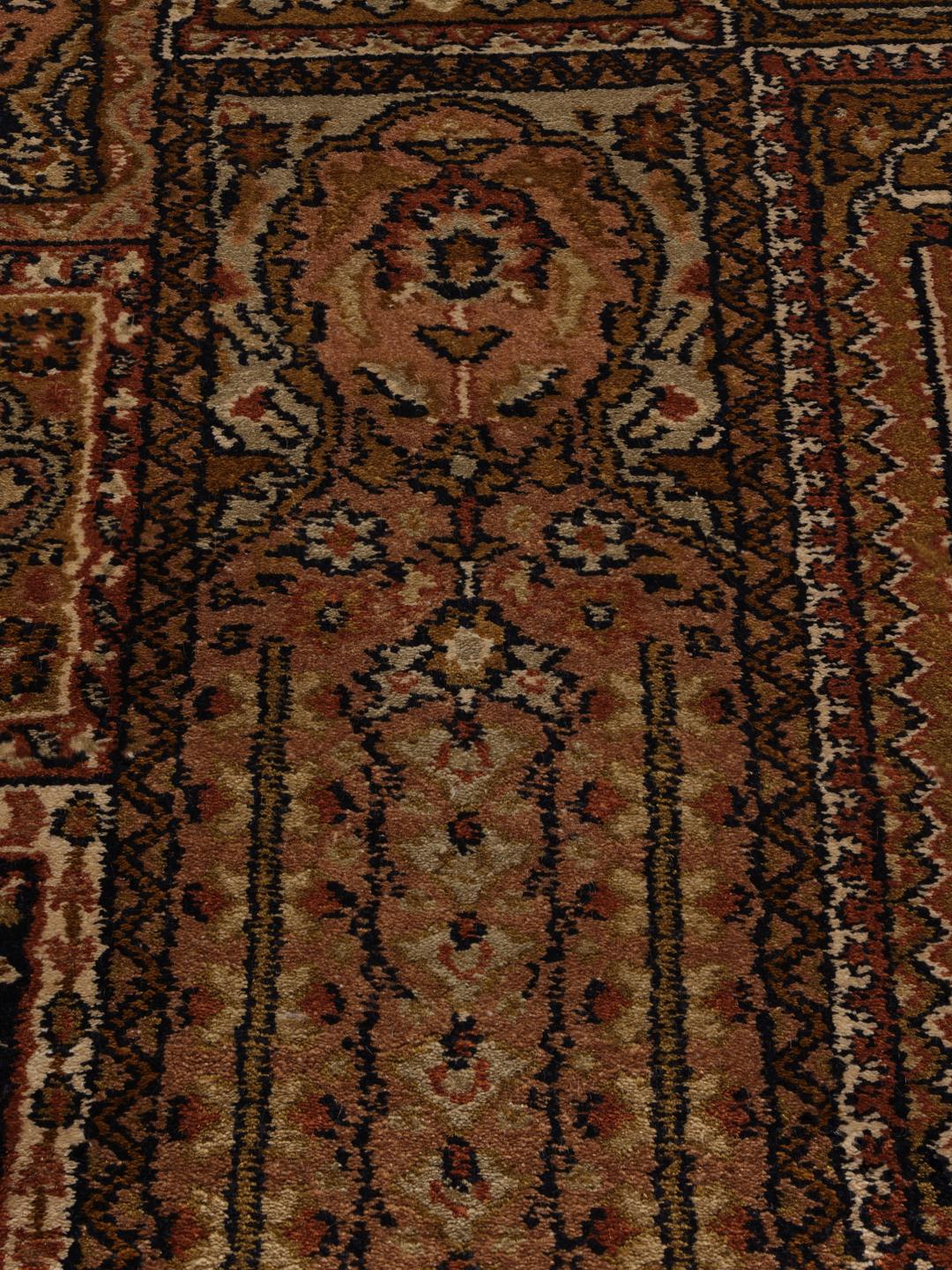 En lang, elegant håndknyttet silkeløber fra Indien med indviklede brune og beige geometriske mønstre.