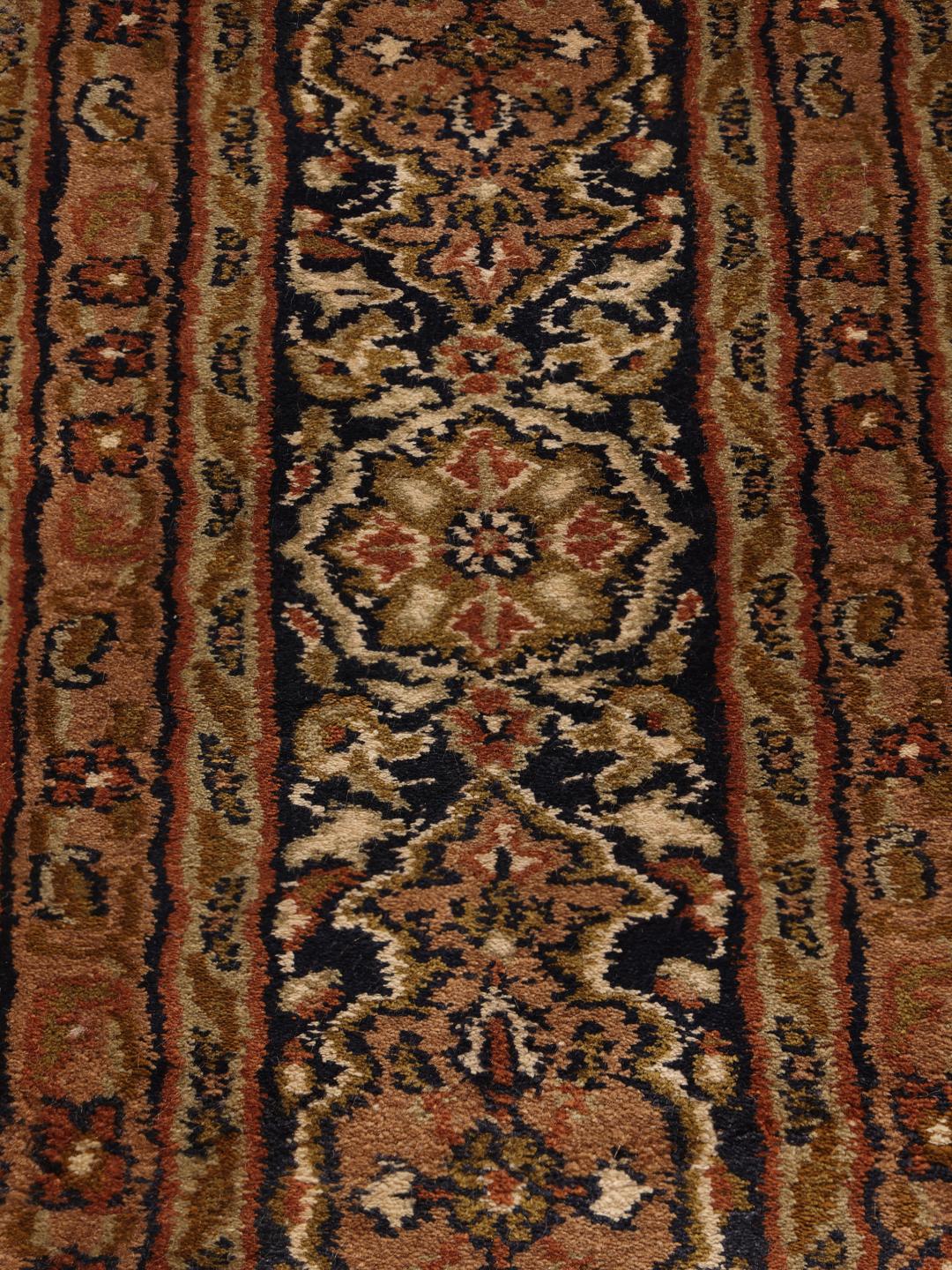 En lang, elegant håndknyttet silkeløber fra Indien med indviklede brune og beige geometriske mønstre.