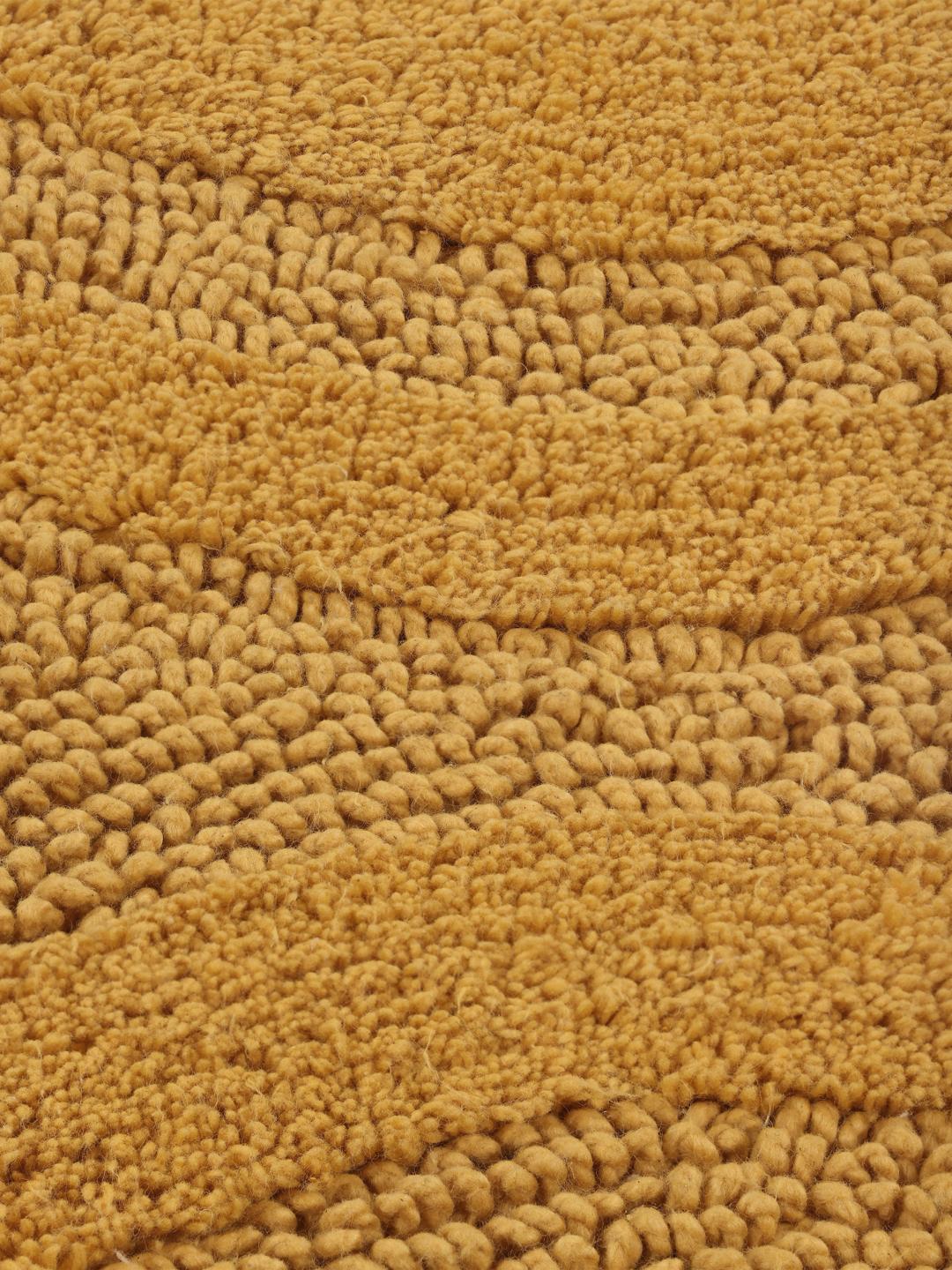 Ronde gele badmat met een gestreept textuurpatroon