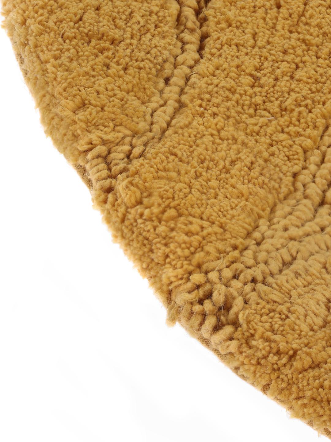 Ronde gele badmat met een gestreept textuurpatroon