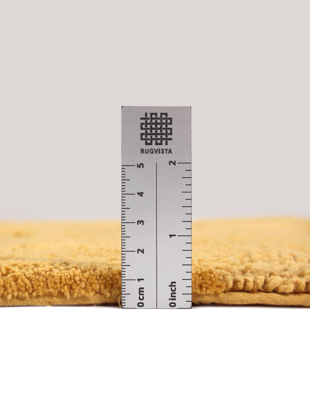 Ronde gele badmat met een gestreept textuurpatroon
