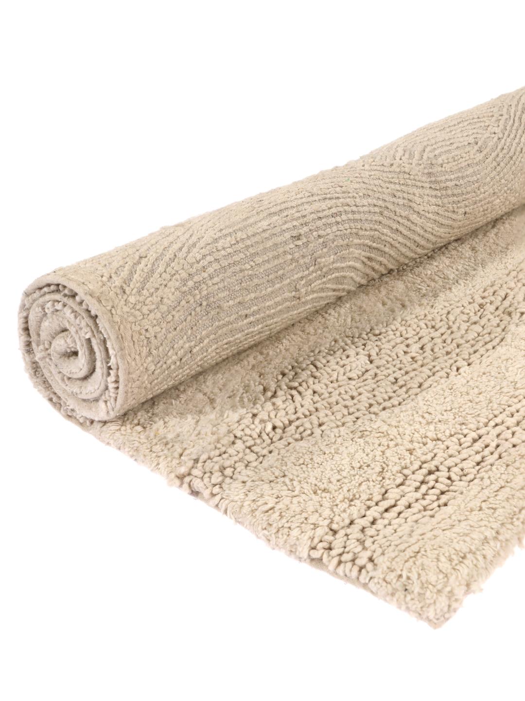 Tapis de bain beige avec un motif à rayures ondulées texturées