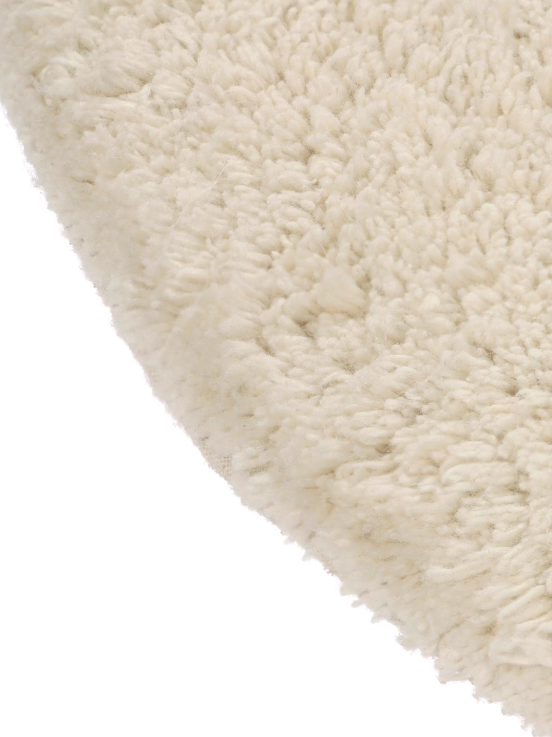 Tapis de bain rond beige avec un motif en relief ondulé texturé