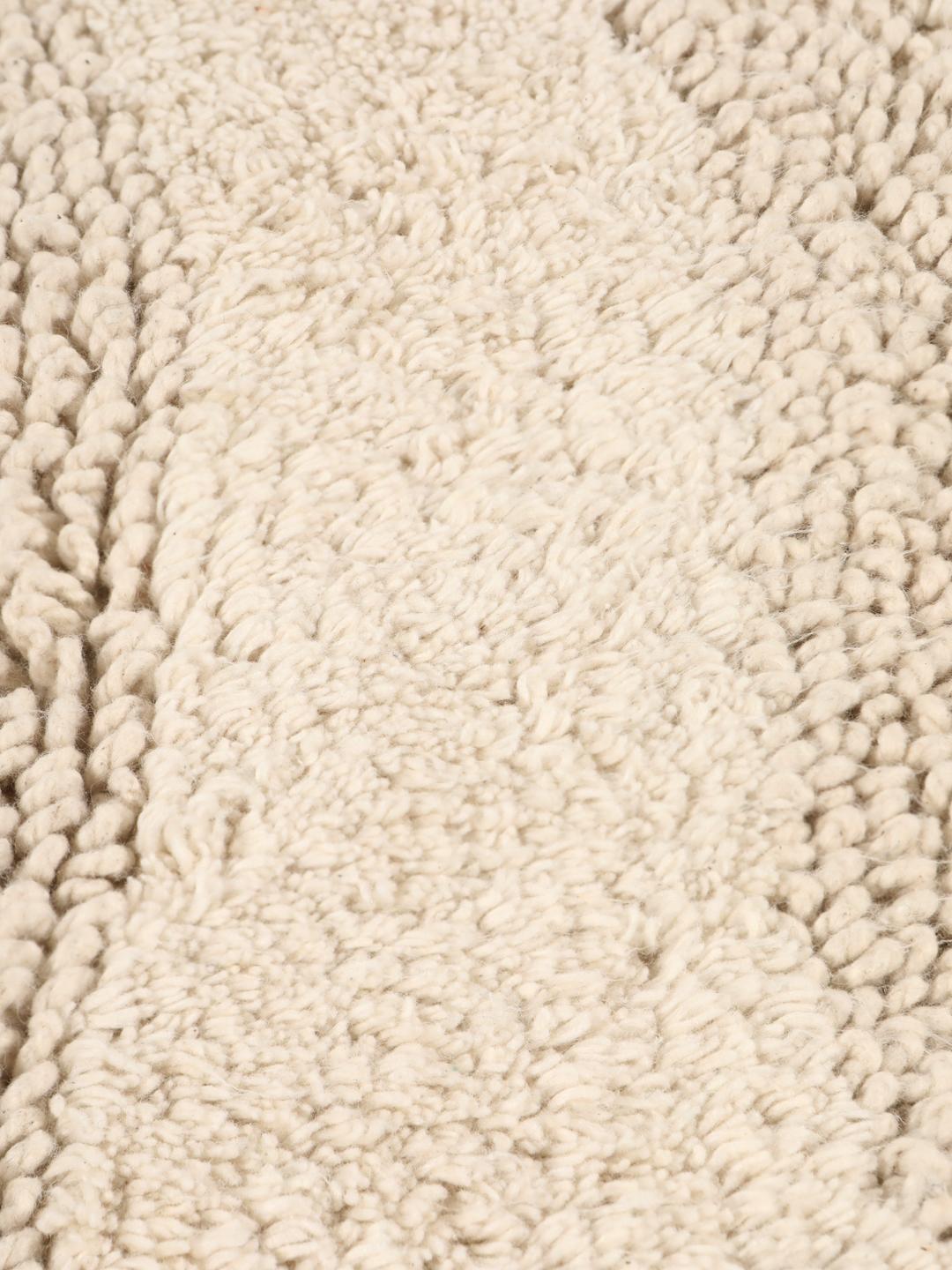 Rund beige bademåtte med et tekstureret bølget reliefmønster