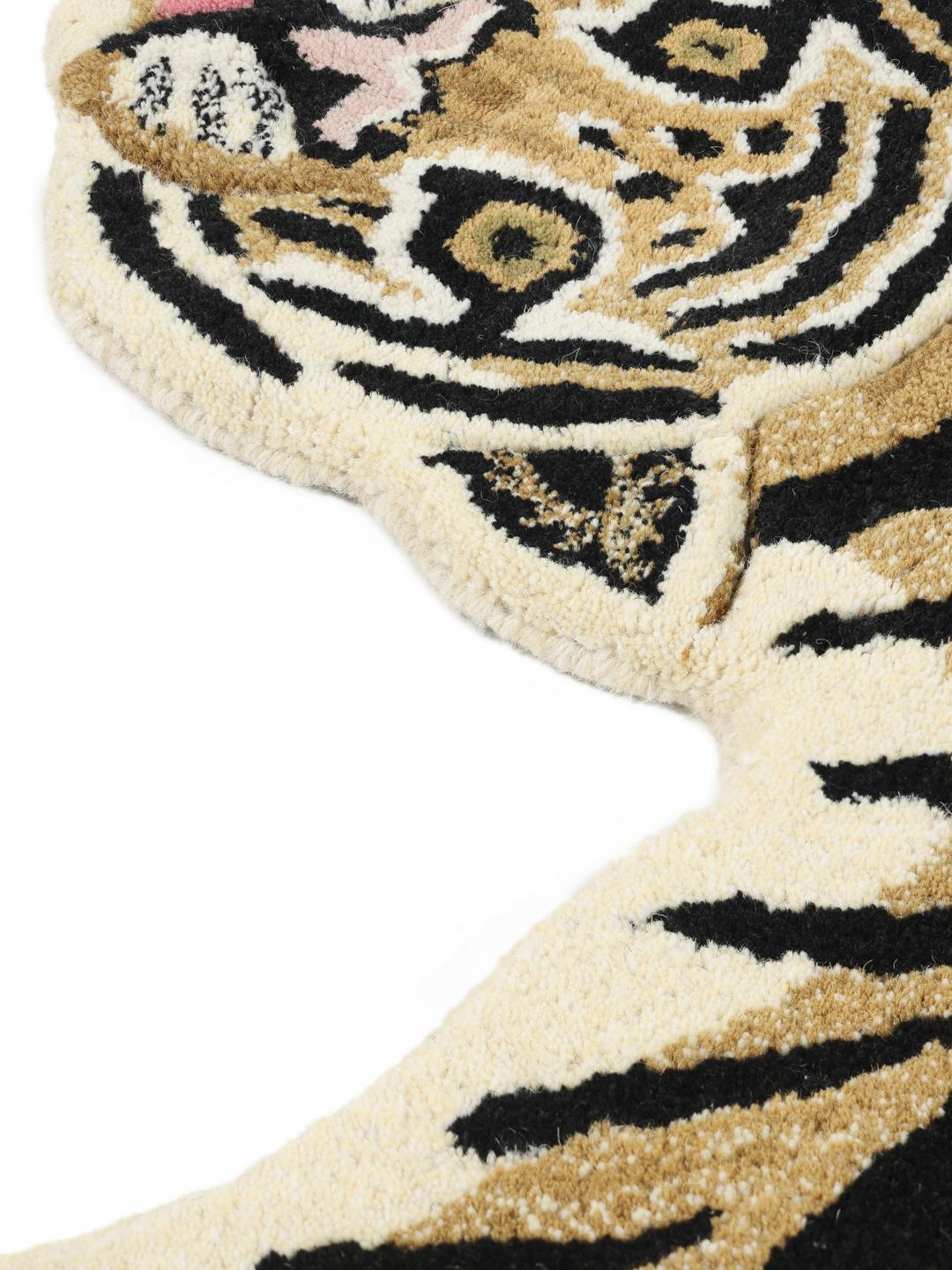 Beige tæppe i en uregelmæssig tigerform med sorte striber