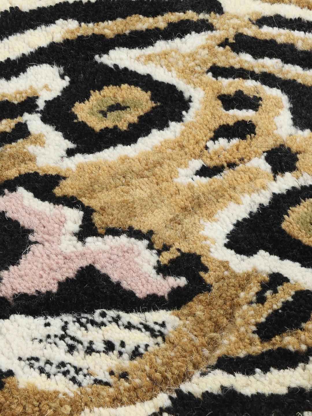 Beige tæppe i en uregelmæssig tigerform med sorte striber