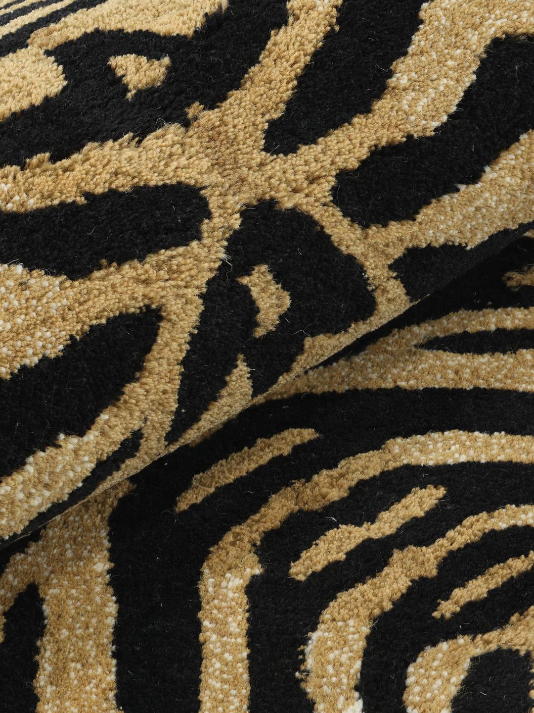 Beige tæppe i en uregelmæssig tigerform med sorte striber