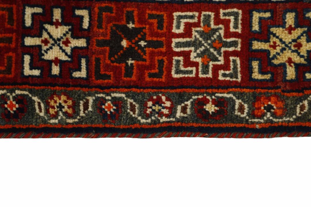 A hand-knotted Kashghai rug from the Middle East with a red field, featuring horse and butterfly motifs.