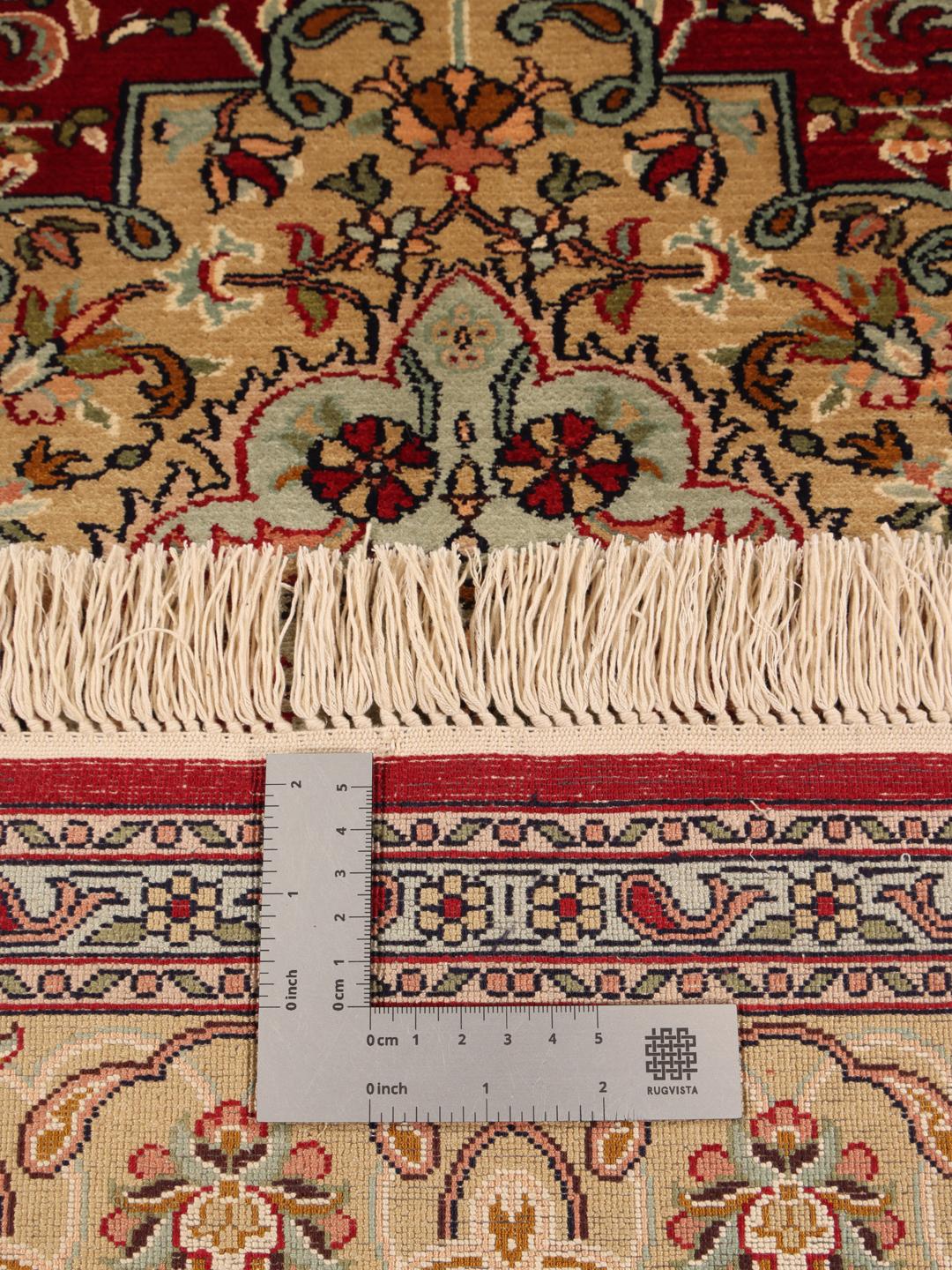 Håndknyttet Kashmir-silketæppe fra Indien med et rødt og beige blomstermedallion-mønster.