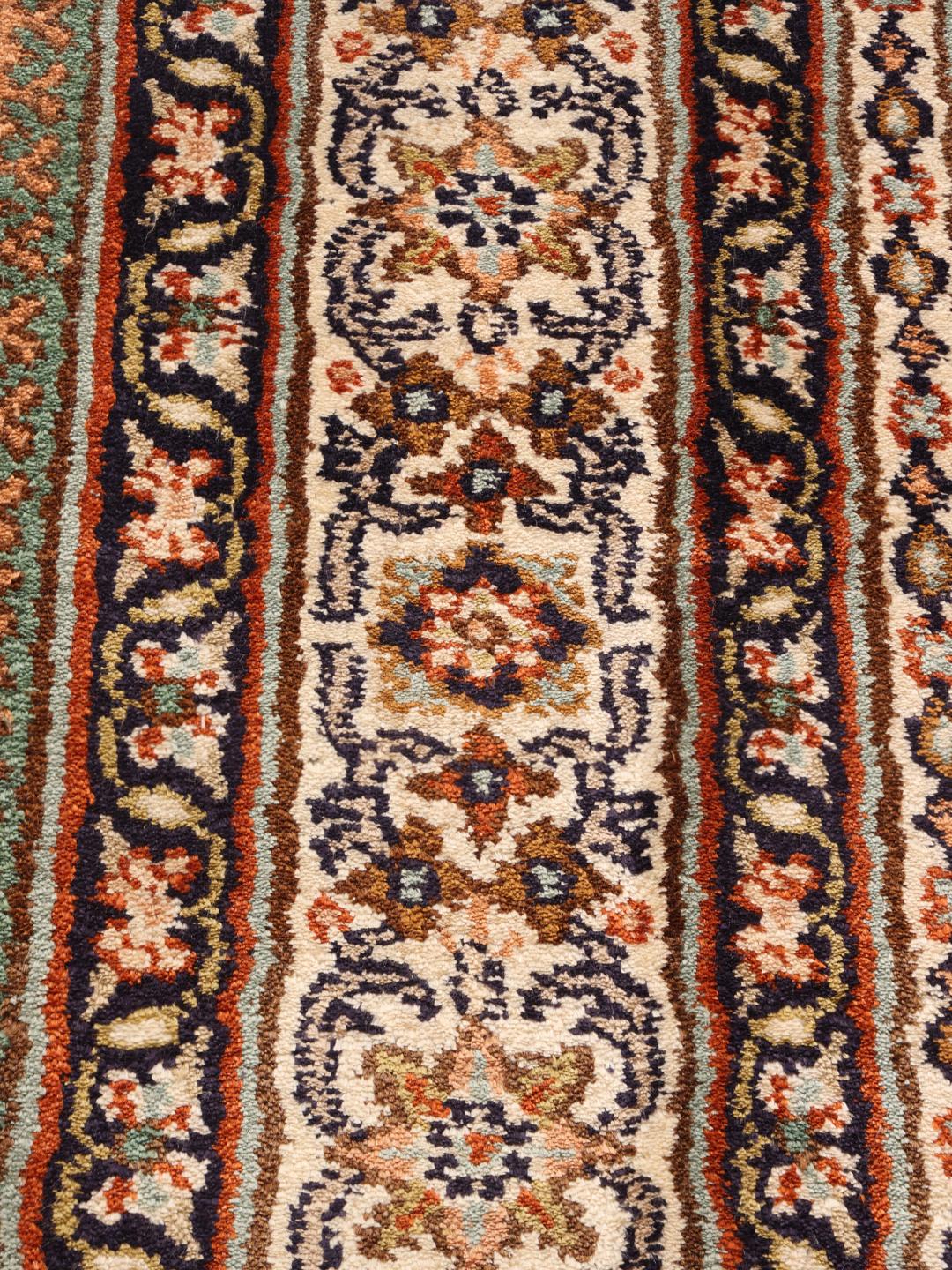 Een rechthoekig, met de hand geknoopt Kashmir zijden tapijt uit India met een veelkleurig bloemenpaneelontwerp.
