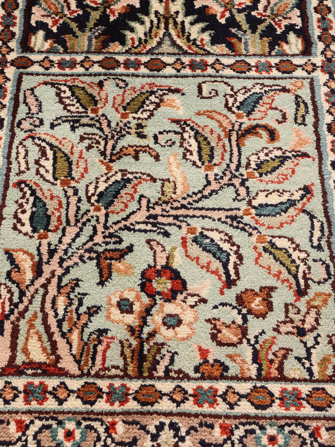 Een rechthoekig Kashmir zijden tapijt uit India met een meerkleurig bloemenpatroon in panelen.