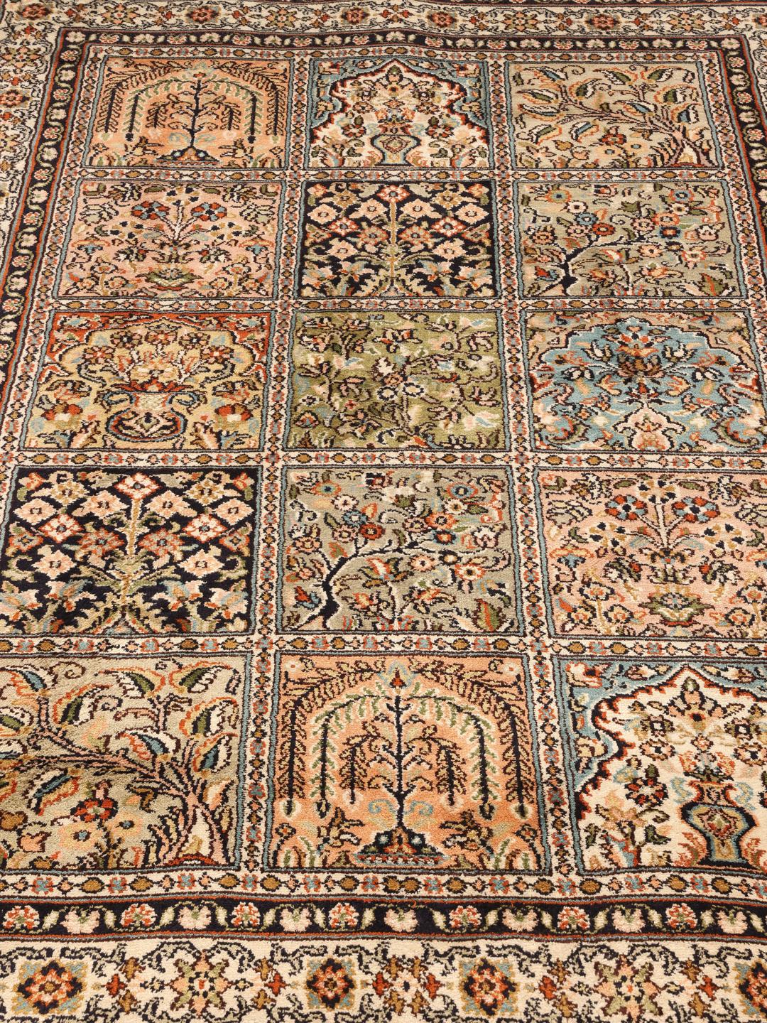 Een handgeknoopt Kashmir zijden tapijt uit India met een beige basis en ingewikkelde bloemenmedaillons.
