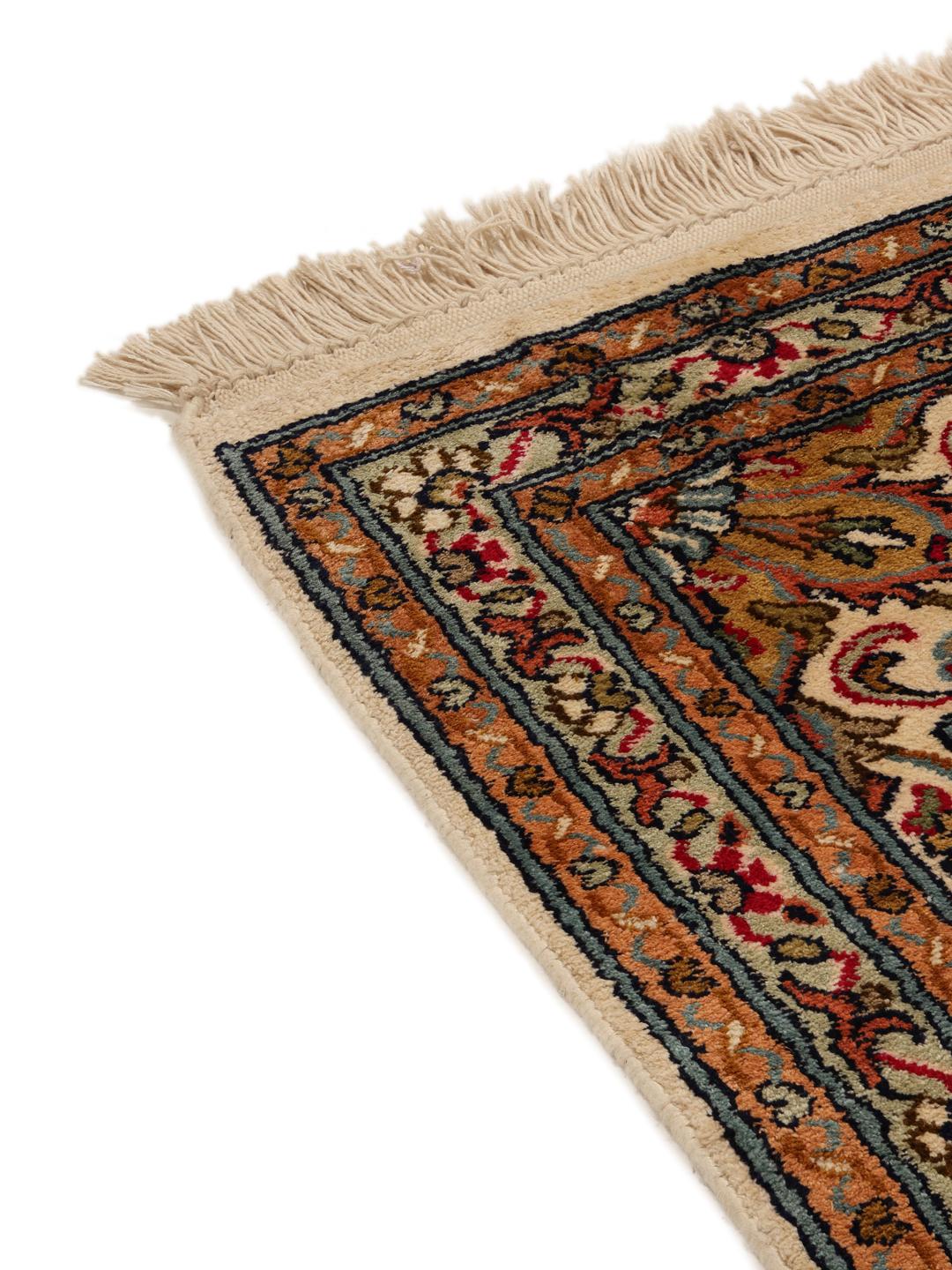 Et håndknyttet Kashmir-tæppe i silke fra Indien med et flerfarvet blomsterdesign.