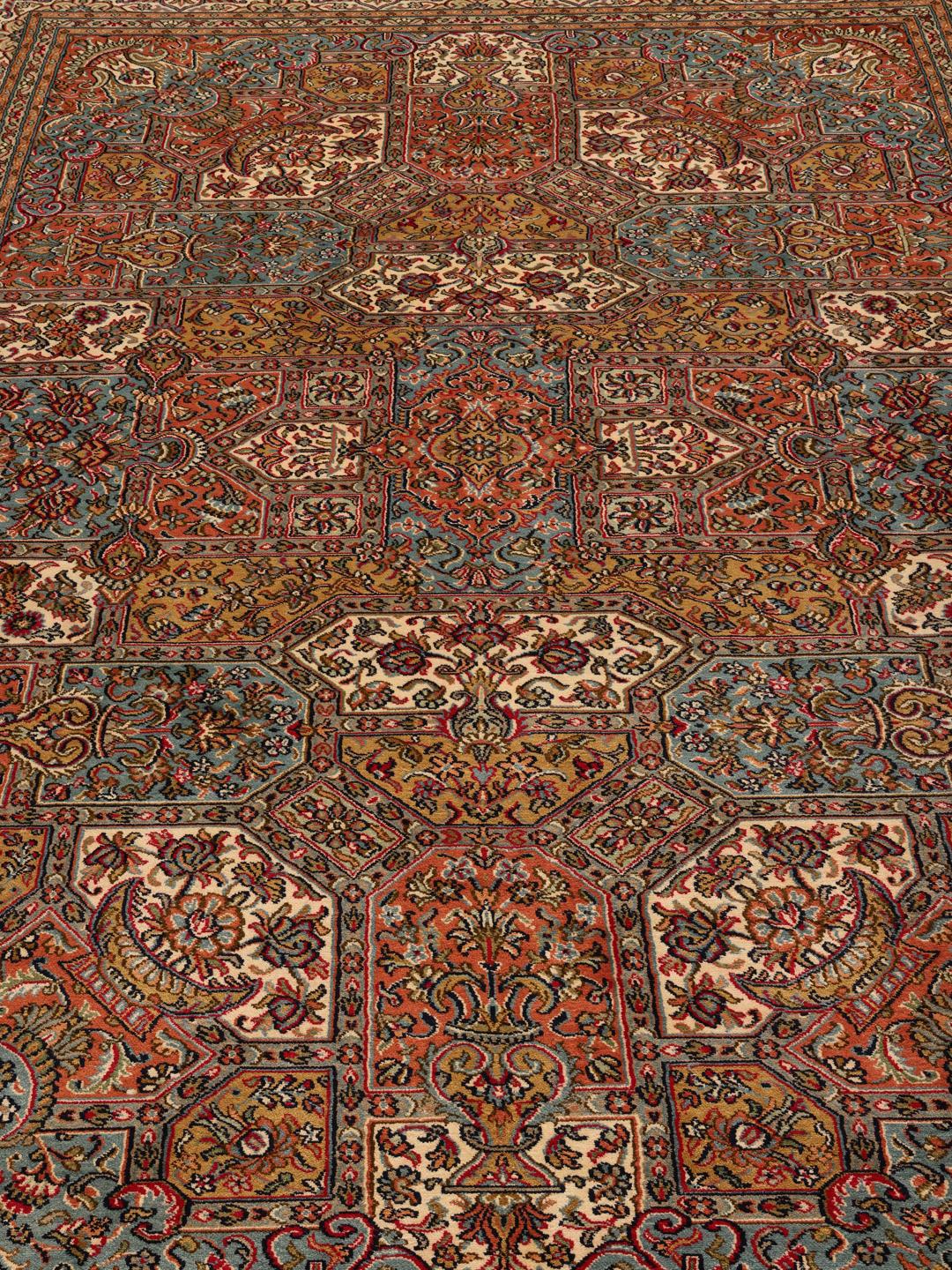 Et håndknyttet Kashmir-tæppe i silke fra Indien med et flerfarvet blomsterdesign.