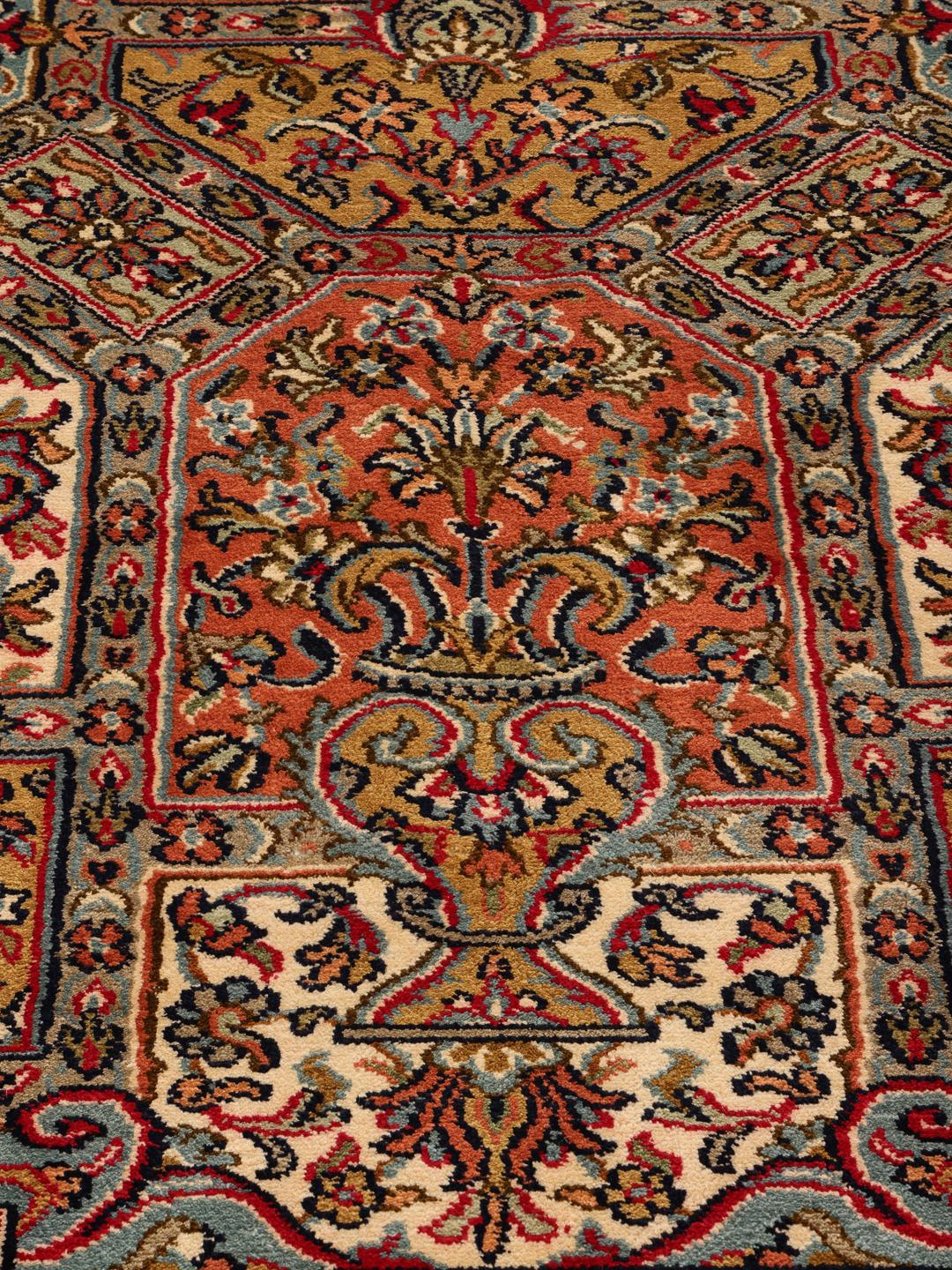 Et håndknyttet Kashmir-tæppe i silke fra Indien med et flerfarvet blomsterdesign.