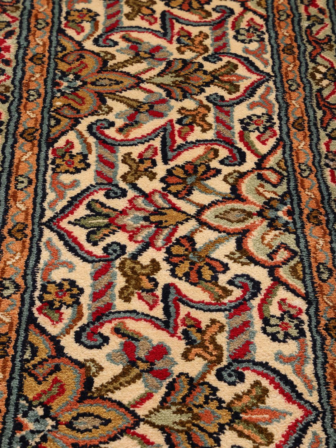 Et håndknyttet Kashmir-tæppe i silke fra Indien med et flerfarvet blomsterdesign.