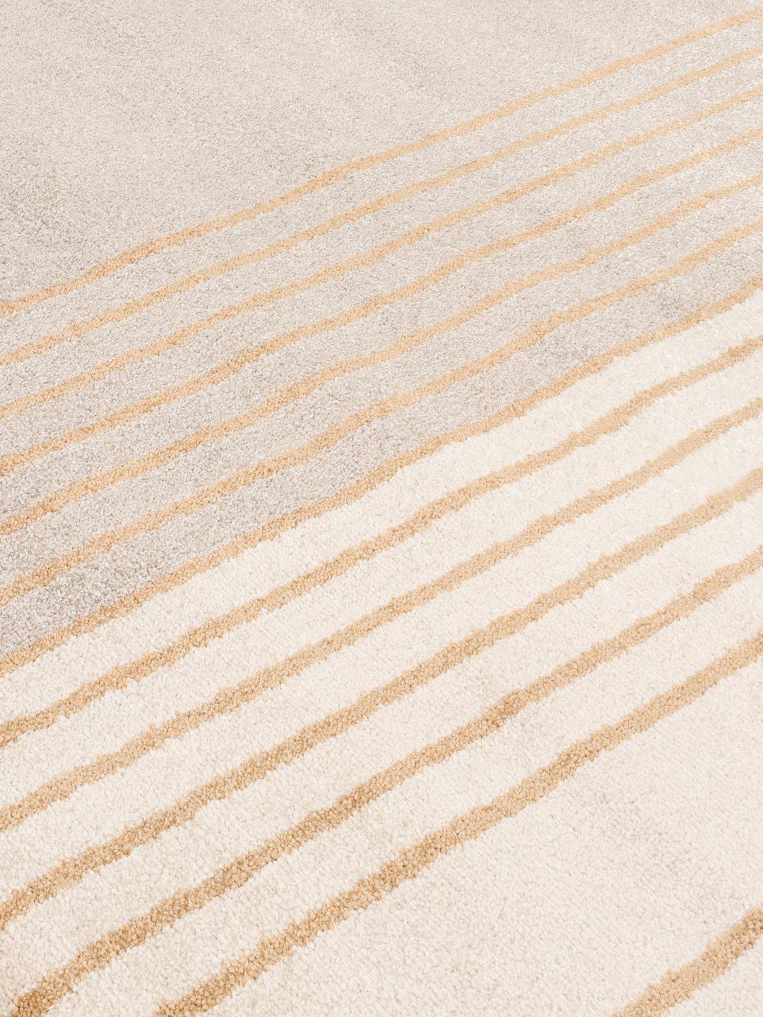 Een rond beige en geel tapijt met abstracte geometrische lijnen.