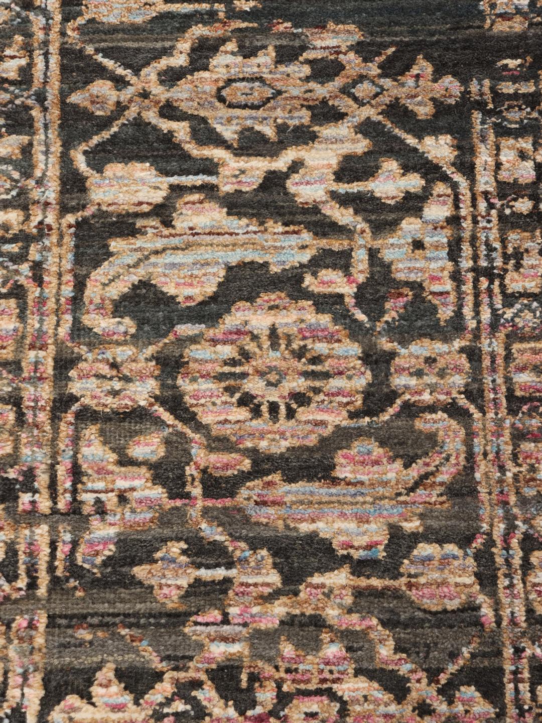 Et mørkt, sofistikeret håndknyttet tæppe fra Indien med fine blomstermotiver og en dyb, stemningsfuld farvepalette.