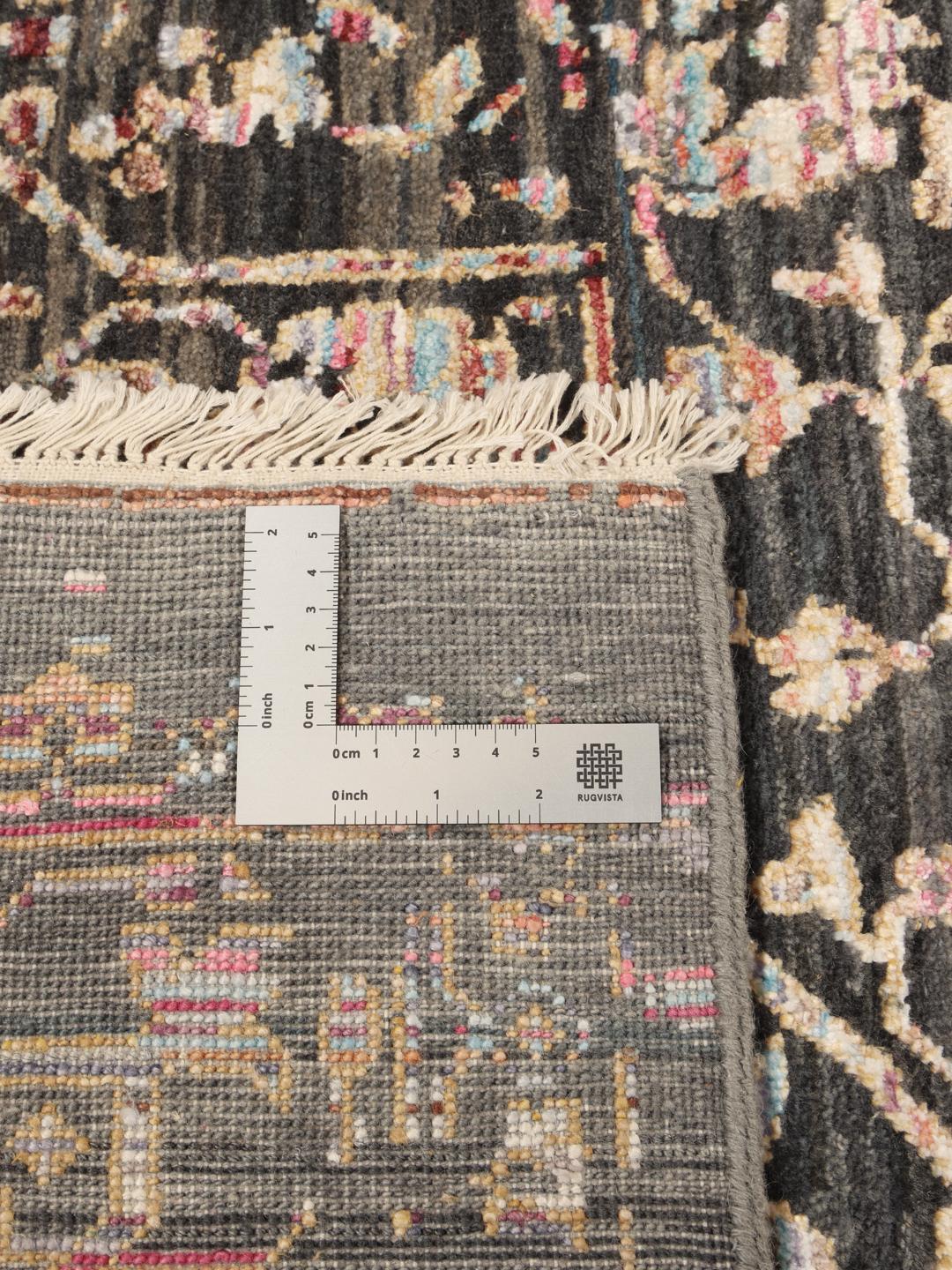 Et mørkt, sofistikeret håndknyttet tæppe fra Indien med fine blomstermotiver og en dyb, stemningsfuld farvepalette.