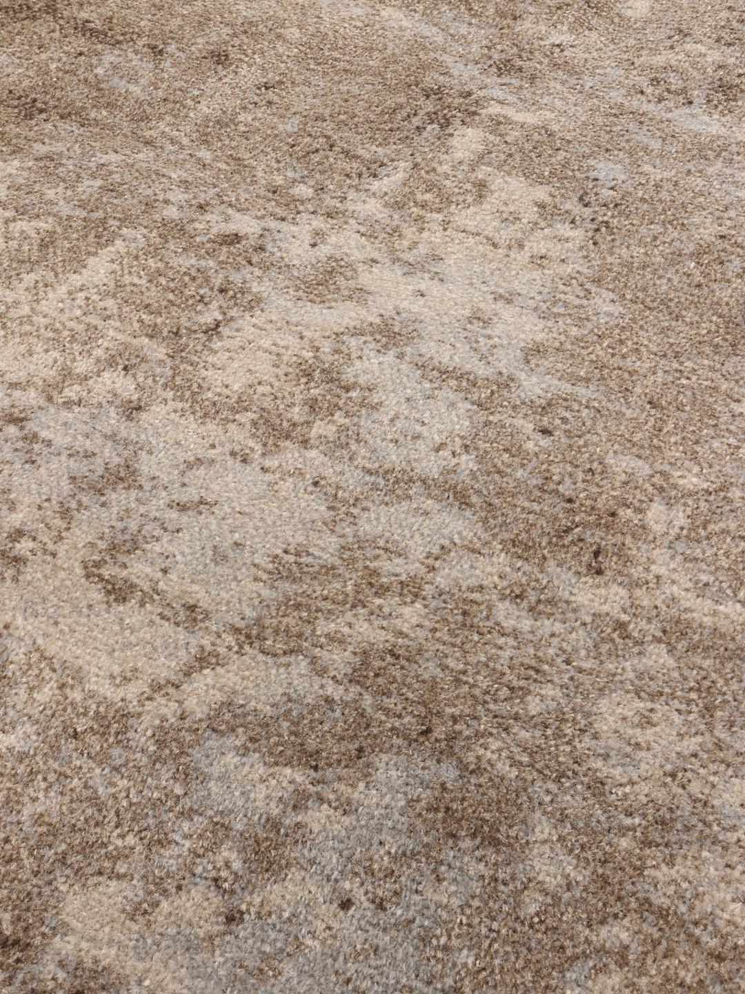 Tapis beige et gris avec un motif patiné et des détails de franges