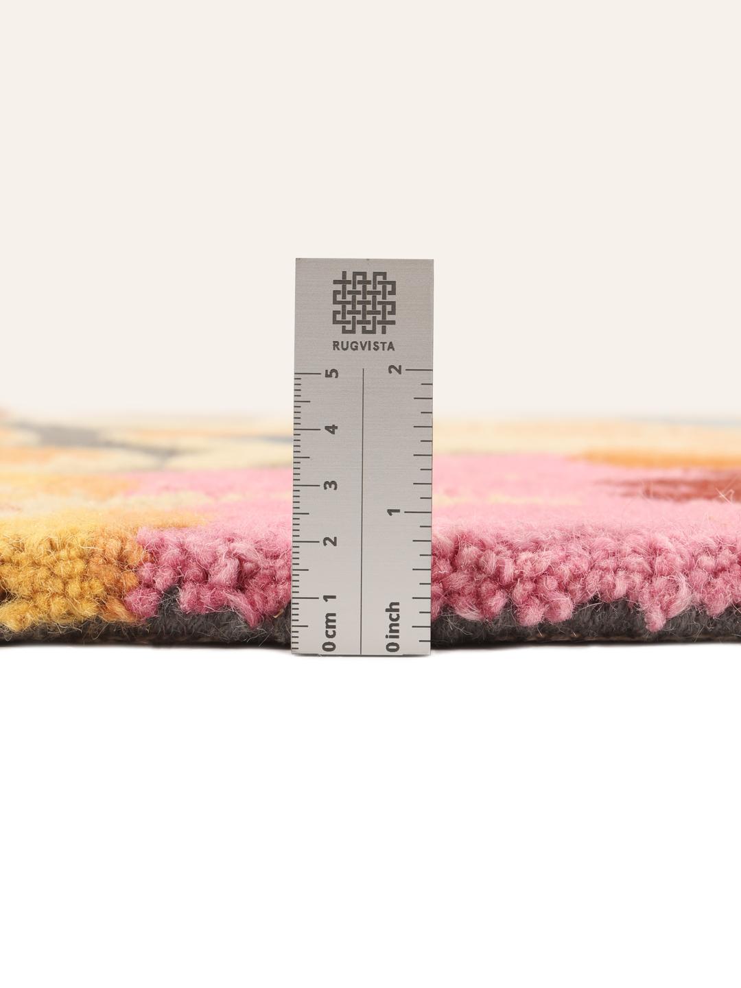 Et rundt flerfarvet tæppe med et modigt og livligt blomstermønster.