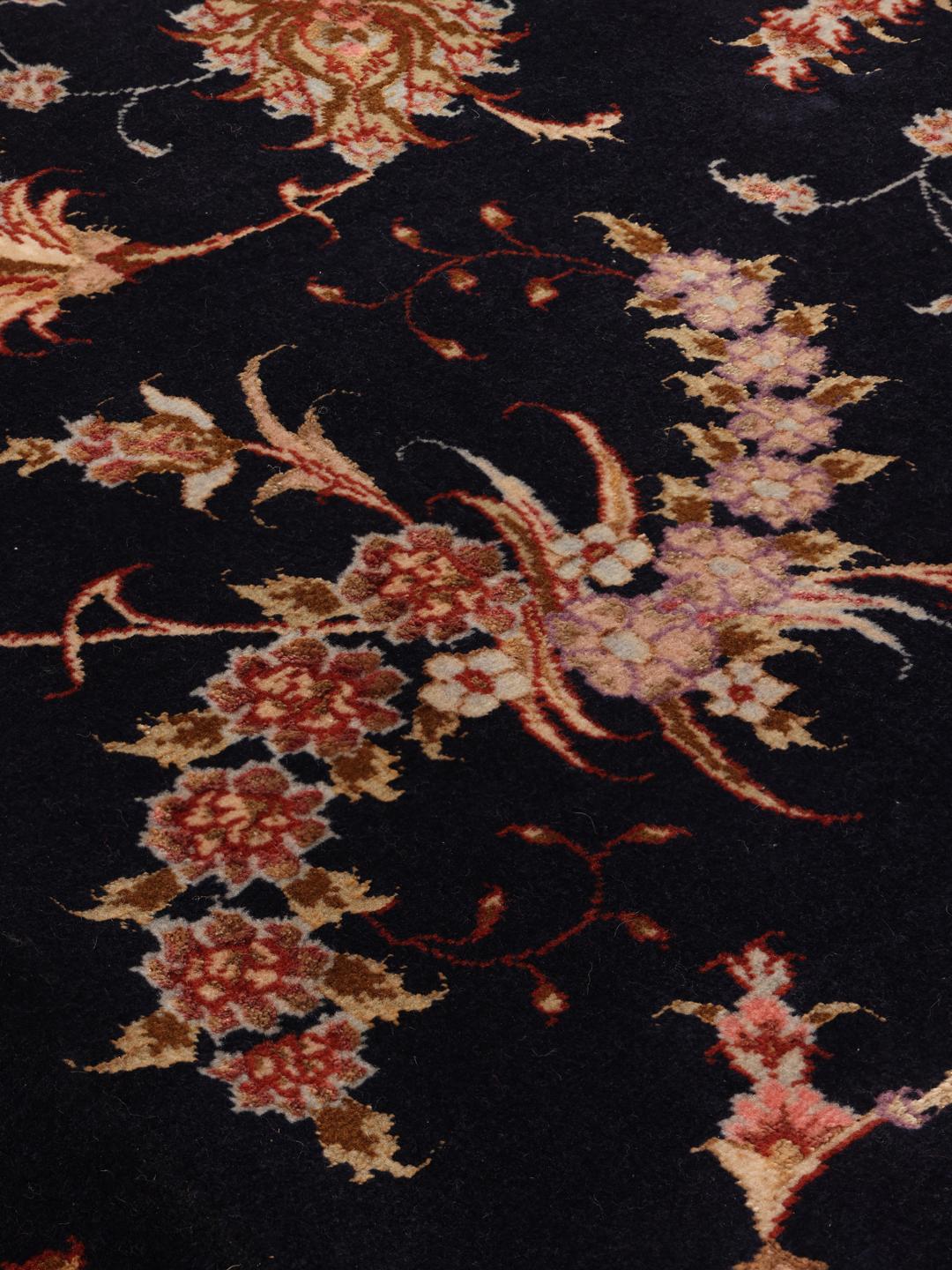 Hand-knotted Tabriz rug with a black field and floral patterns from the Middle East