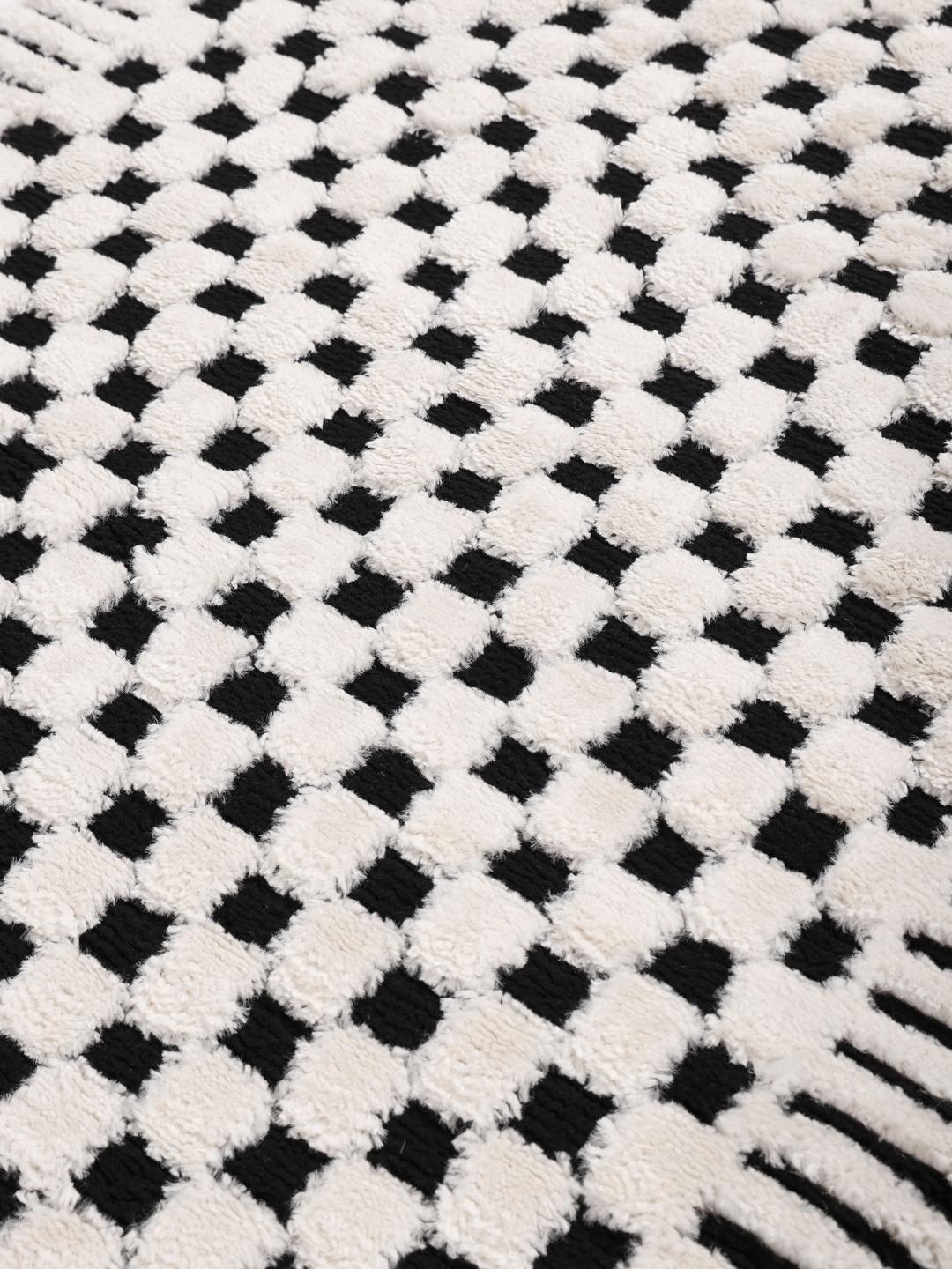 Tapis blanc crème et noir avec un motif structuré