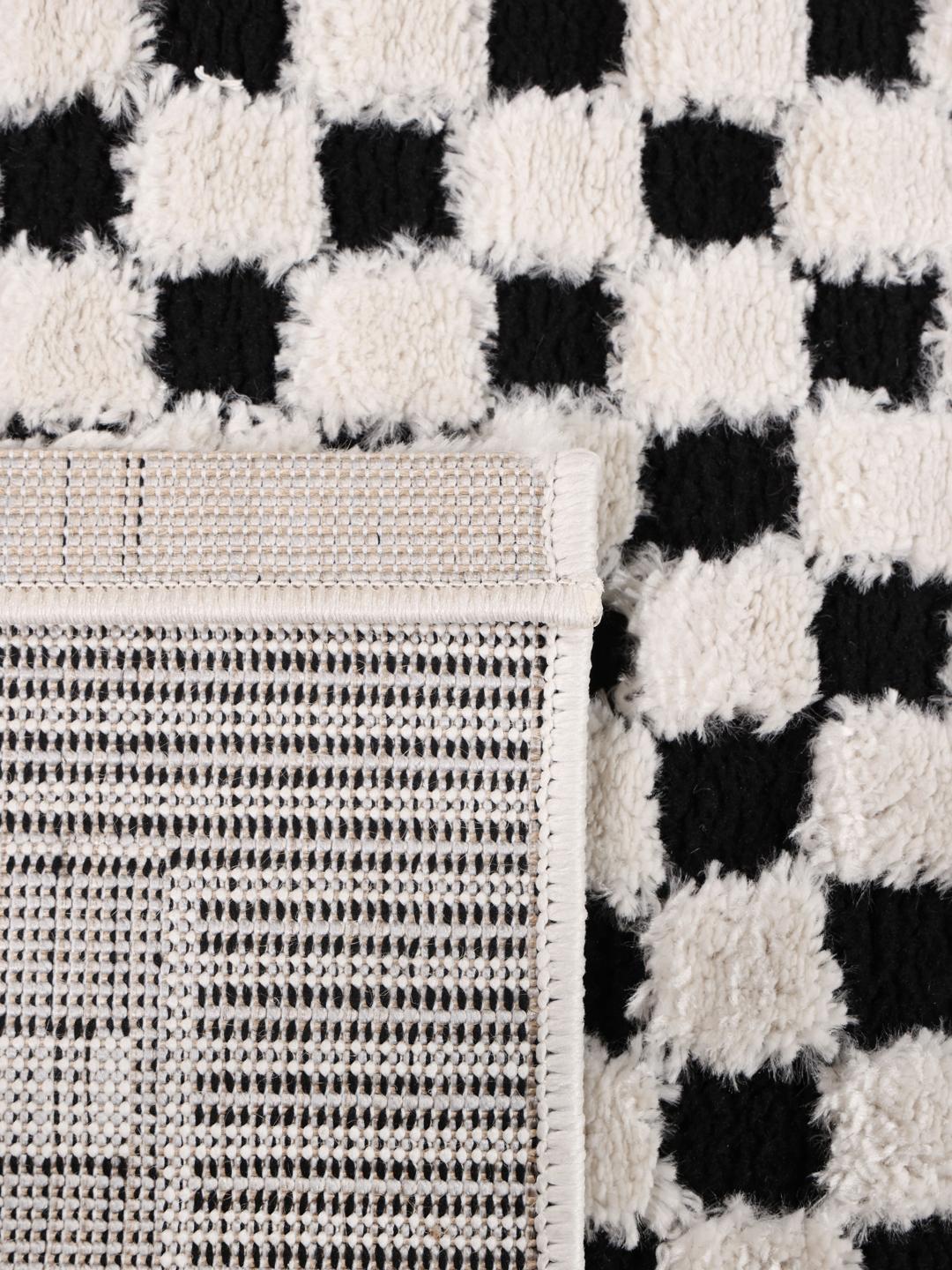 Tapis blanc crème et noir avec un motif structuré