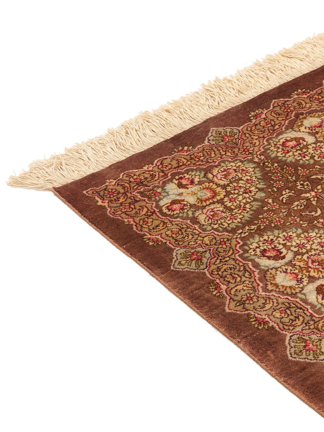 Een luxueus, handgeknoopt Ghom zijden tapijt met ingewikkelde bloemmotieven in bruine en beige tinten, afkomstig uit het Midden-Oosten.