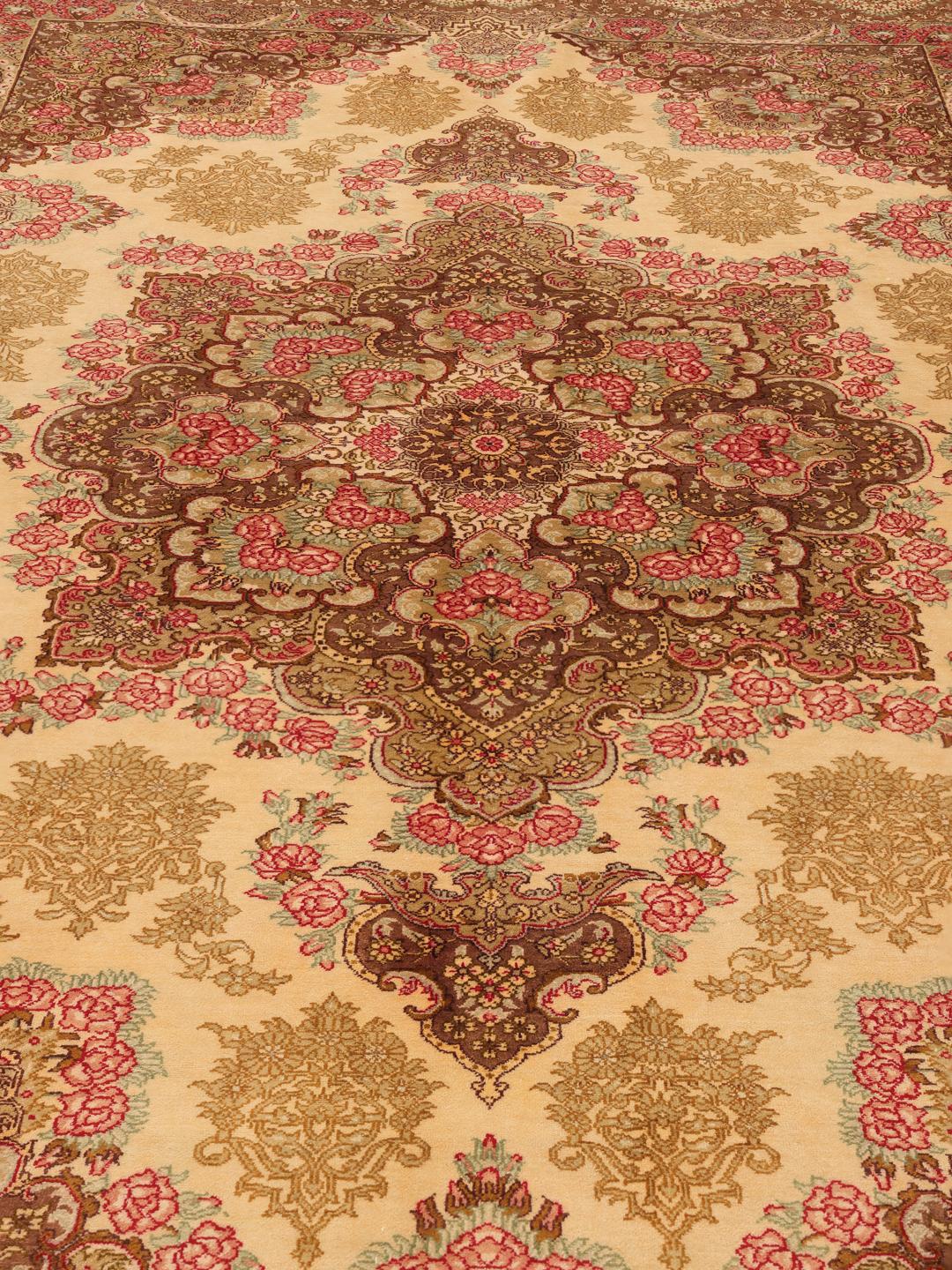 Een luxueus, handgeknoopt Ghom zijden tapijt met ingewikkelde bloemmotieven in bruine en beige tinten, afkomstig uit het Midden-Oosten.