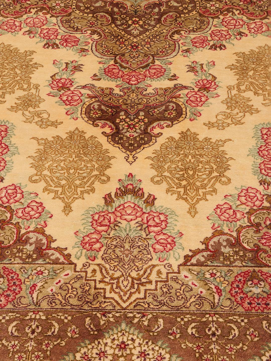 Een luxueus, handgeknoopt Ghom zijden tapijt met ingewikkelde bloemmotieven in bruine en beige tinten, afkomstig uit het Midden-Oosten.