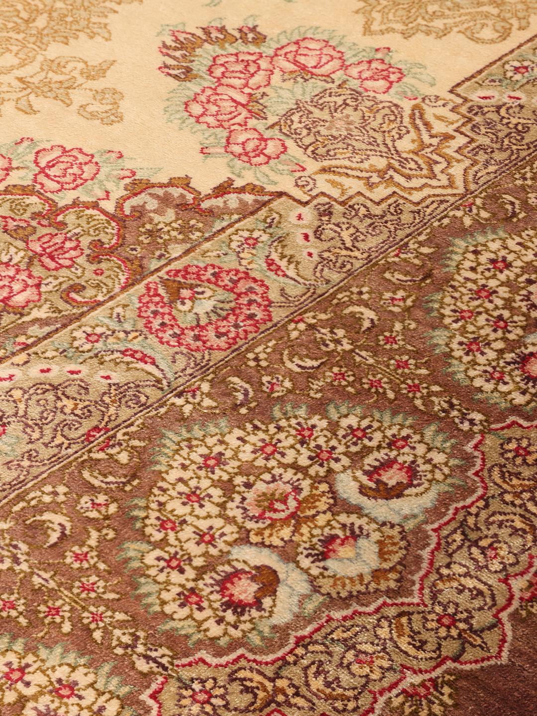 Een luxueus, handgeknoopt Ghom zijden tapijt met ingewikkelde bloemmotieven in bruine en beige tinten, afkomstig uit het Midden-Oosten.